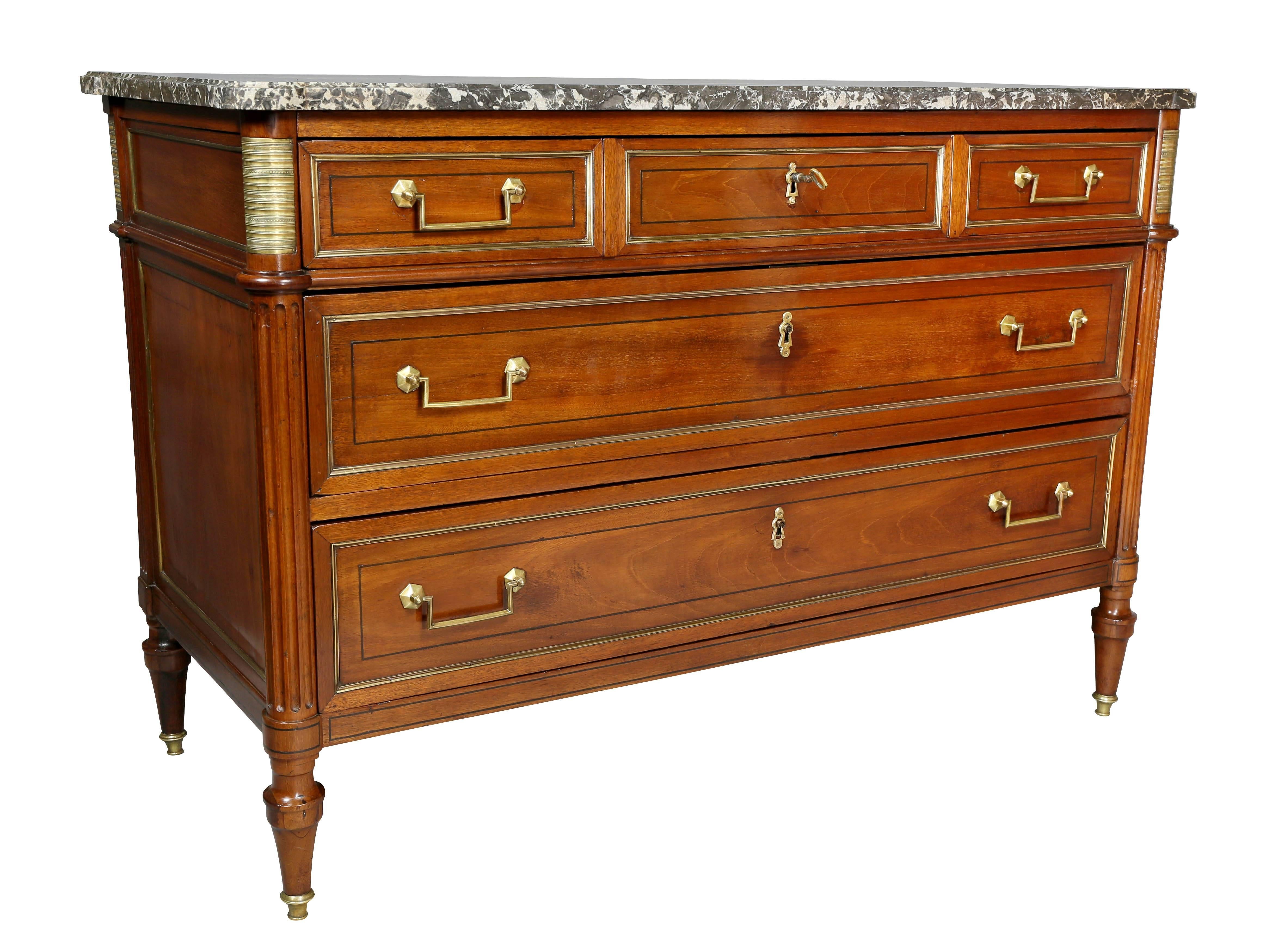 Rectangular St Anne gray marble top with rounded corners, over three drawers flanked by reeded columns all brass-mounted, raised on circular tapered legs.