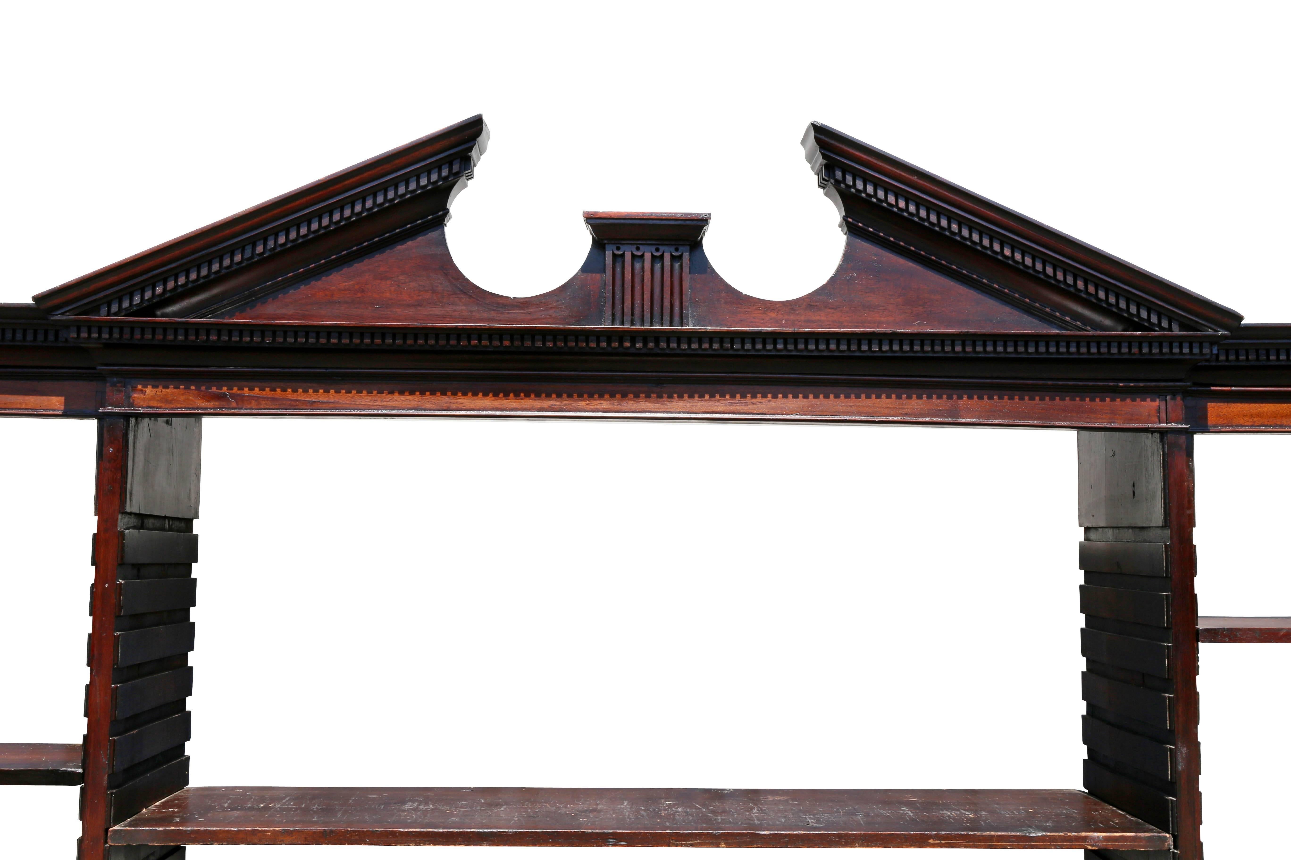 Broken arch pediment with with dentilled cornice over three bookcase sections with adjustable shelves, the base with panelled doors. Comes apart in four sections.