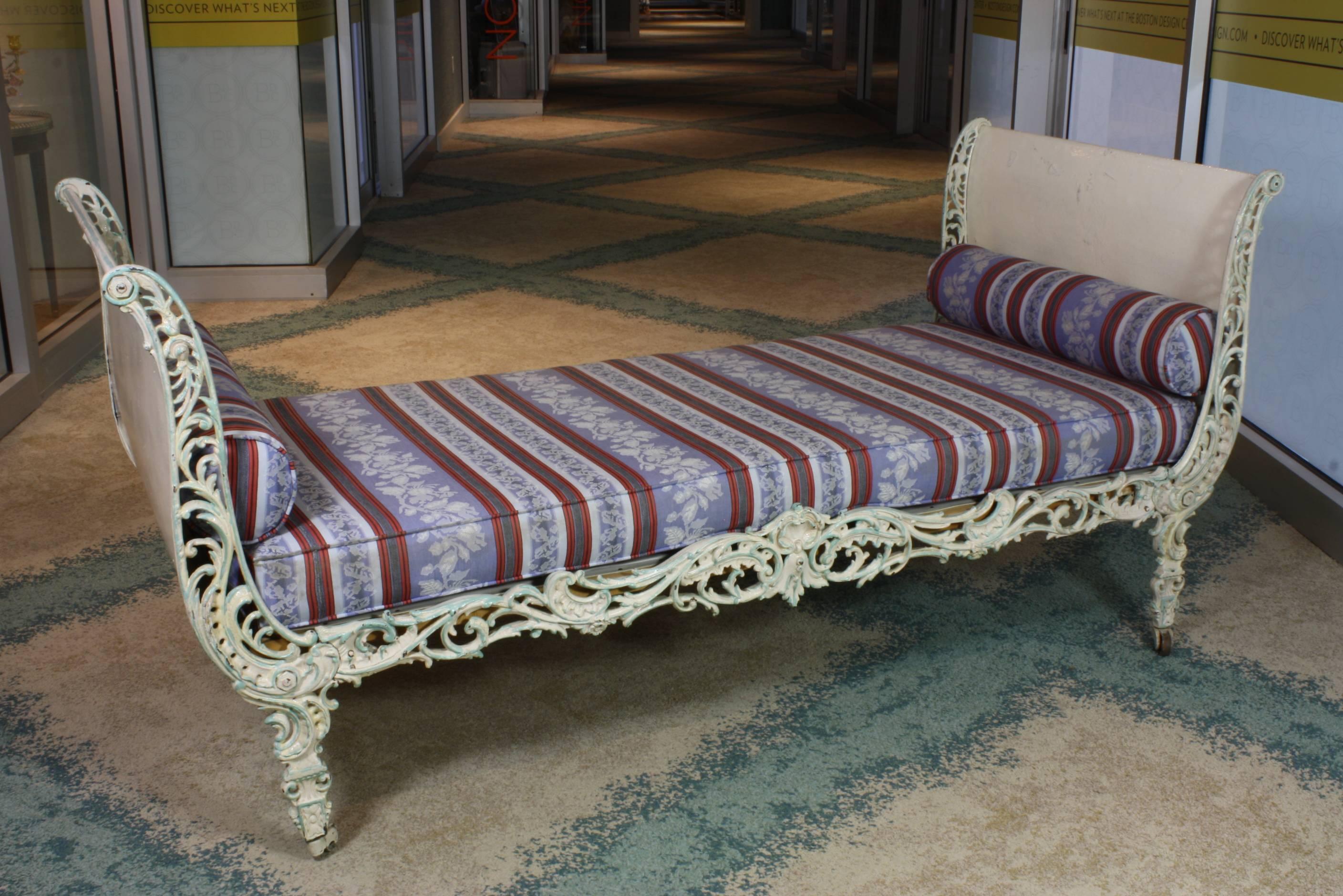 Very decorative French Louis XV or Rococo style painted cast-iron daybed with original casters (late 19th century). The daybed includes a seat cushion and two bolster pillows (the seat cushion has a width about 3 ½