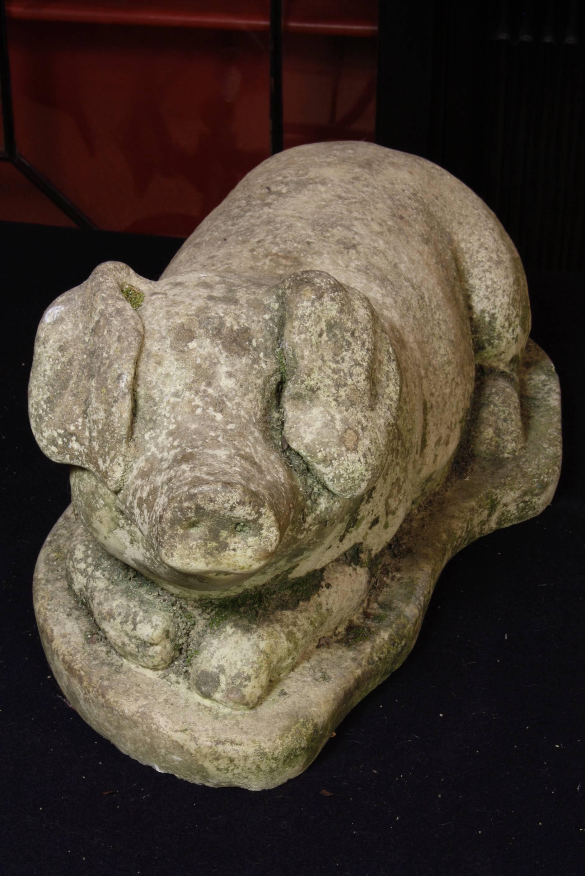 Very cute French reclining pig in composite stone (late 19th-early 20th century). This adorable guy appears to be smiling, with large floppy ears covered his eyes and a small curly-cue tail at his opposite end. We call him "Truffles".
