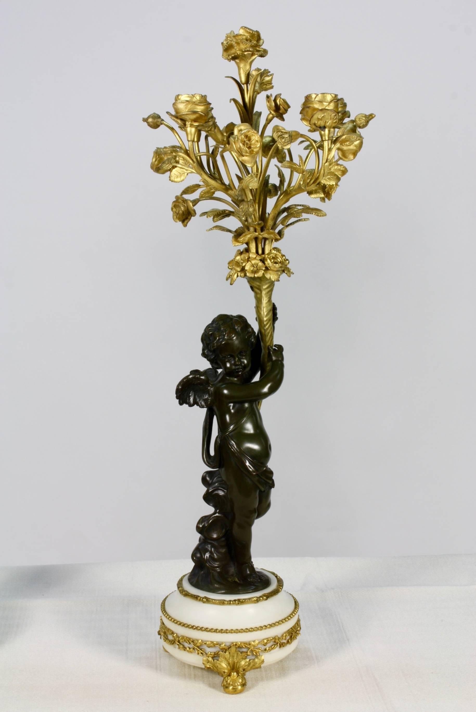 Louis XVI Paire de candélabres en bronze doré et patiné avec putti tenant des bouquets de fleurs en vente