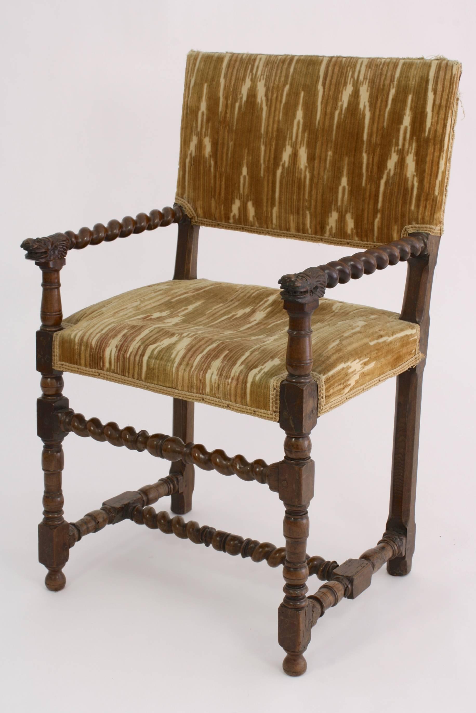 Louis XIII period walnut fauteuil or armchair with barley arms ending in carved lions' heads.  Other elements are turned or carved barley twist designs.  Appears that at least the rear right leg may have been replaced.  Vintage patterned silk velvet