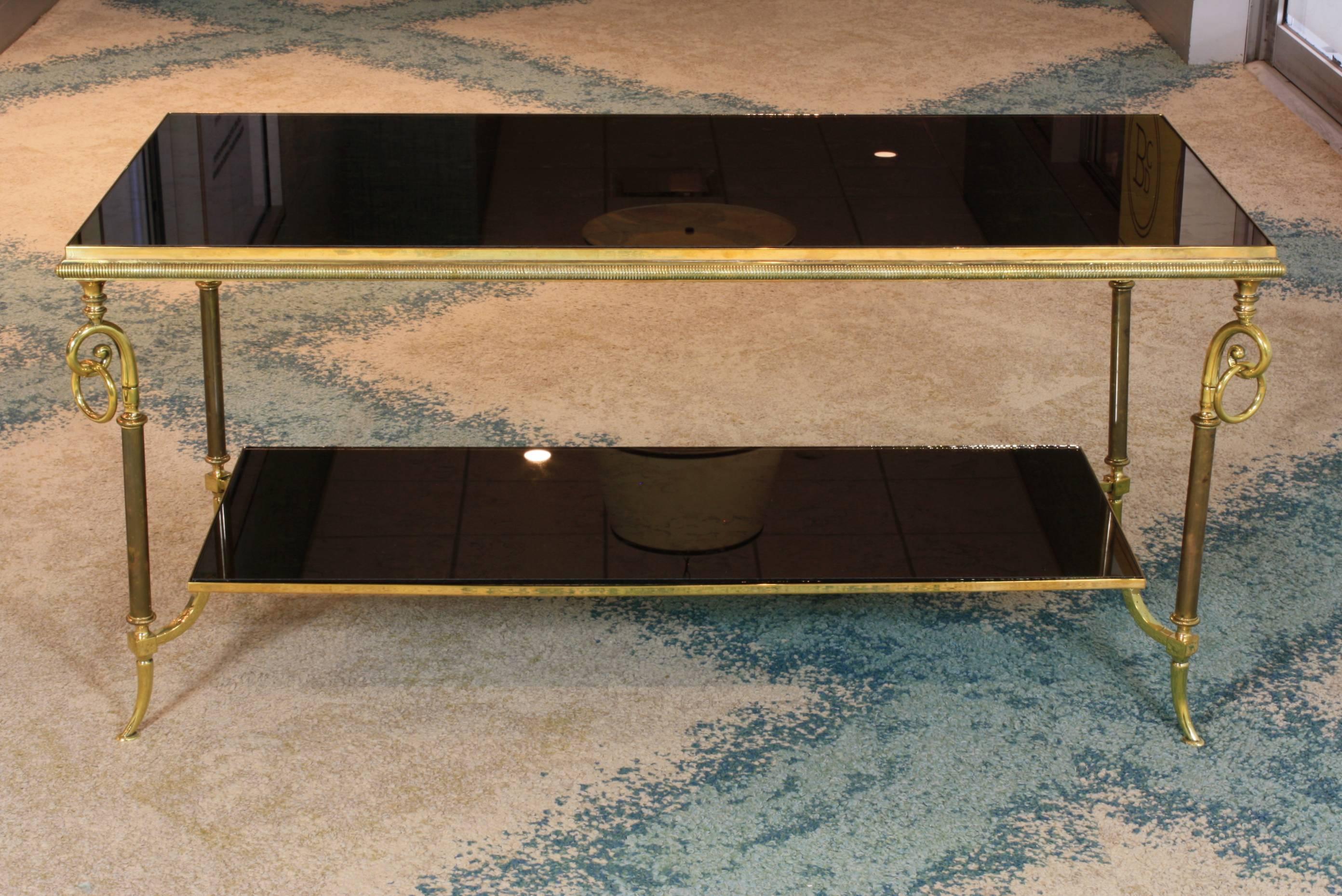 French two-tiered coffee table with polished and patinated brass legs, scrolls and rings in each corner, and églomisé mirror tops attributed to Maison Jansen.