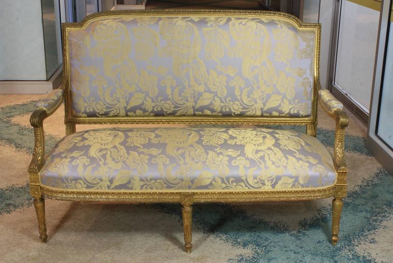French Louis XVI style giltwood settee with nice acanthus leaf and bead carved elements and rosettes on joints (Circa 1880). Relatively recent Italian silk upholstery with gimp trim.