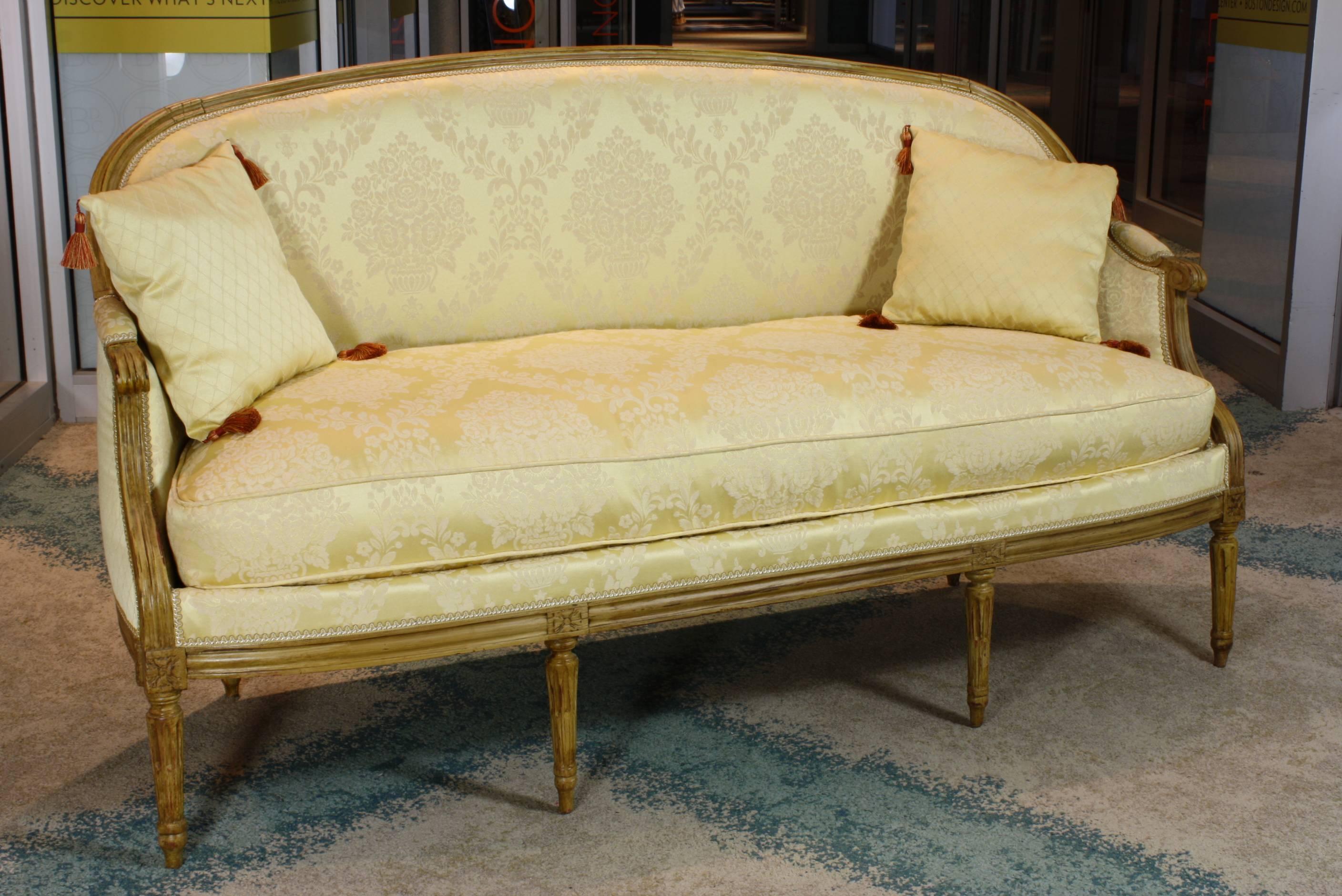 An elegant neoclassical Louis XVI period sofa or canapé, with down-stuffed separate seat cushion, two small tasseled pillows, painted frame, and tapered fluted legs.  Sofa has been mostly re-upholstered, with new trellice-patterned yellow fabric on