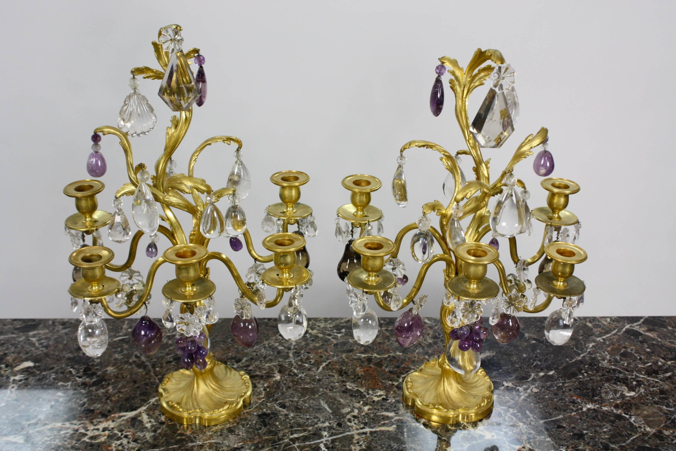 A very high quality pair of French 19th century, Louis XV style, gilt-bronze girandoles with five arms, beautiful rock crystal, including rock crystal drops in scallop form, amethyst rock crystal fruit, and pale topaz-colored crystal kites. 