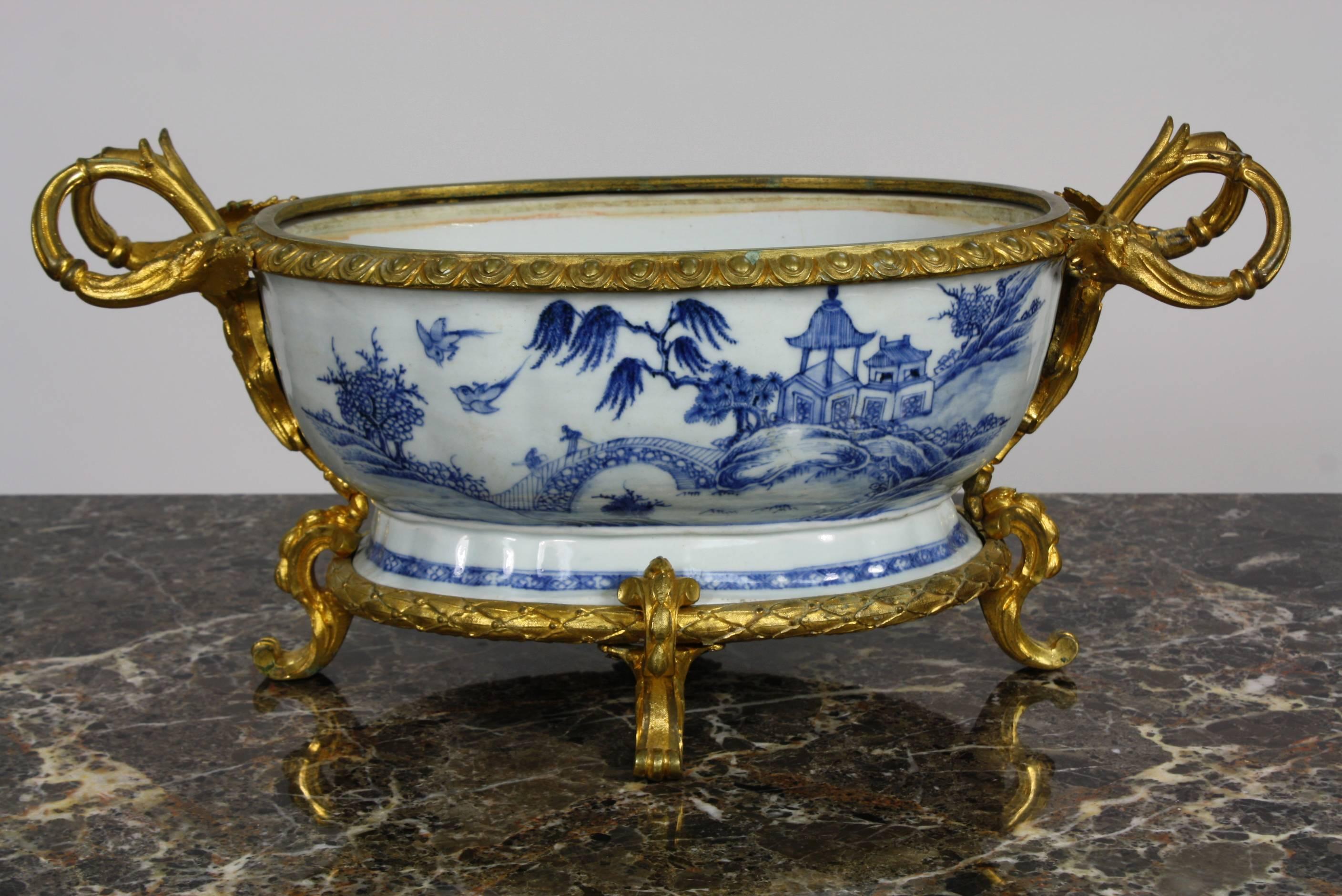 A very high quality, eye-catching 19th century, French, jardinière in blue and white porcelain with Chinoiserie scene featuring a pagoda, birds and river under a bridge. The gilt bronze mounts are in the Louis XV style and are finely-chased.