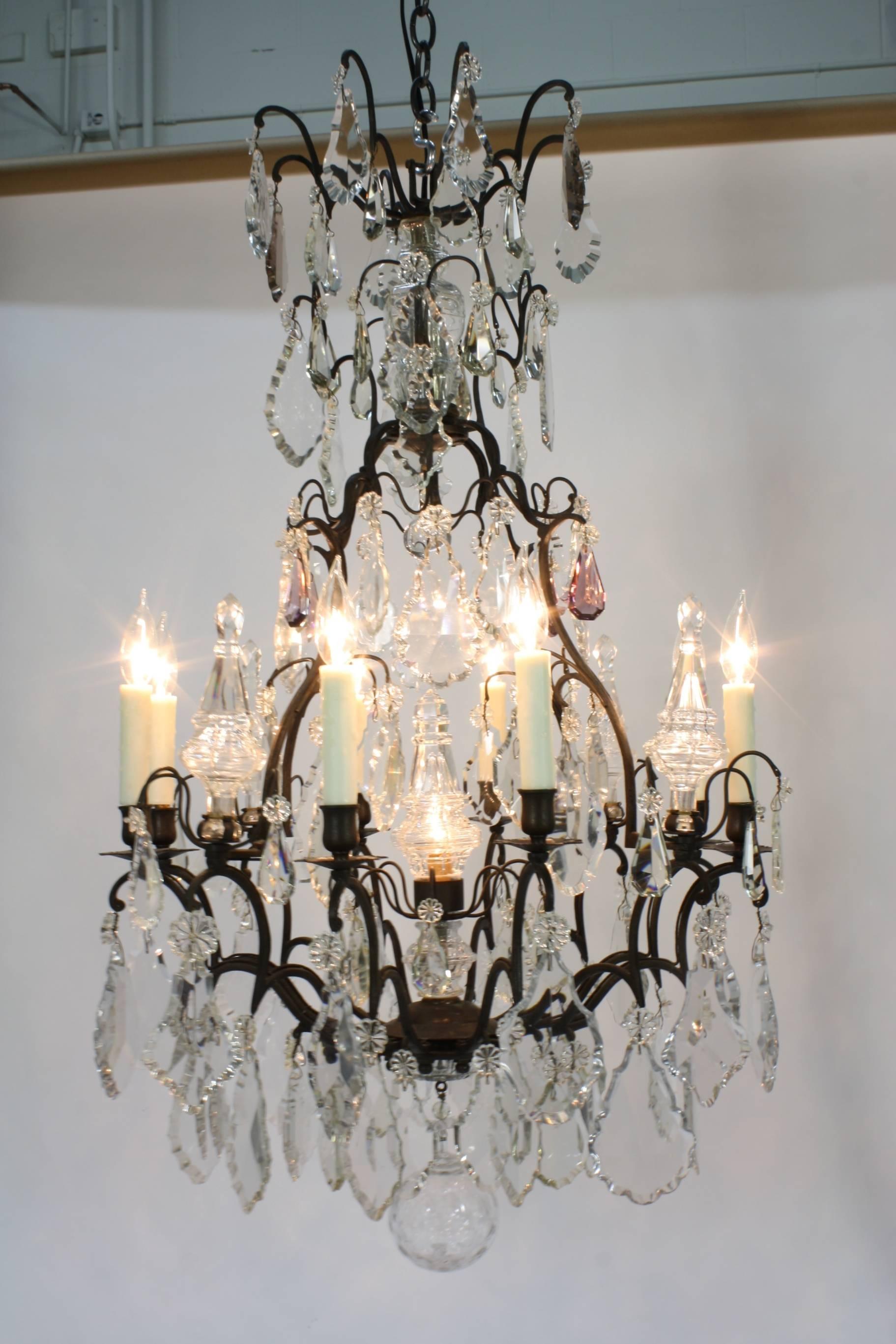 An impressive French patinated bronze cage-form chandelier, with a nice array of crystals (including some pale lavender crystals) and a large crystal ball. The chandelier has been recently re-electrified, with new dripped-wax candle covers, and has