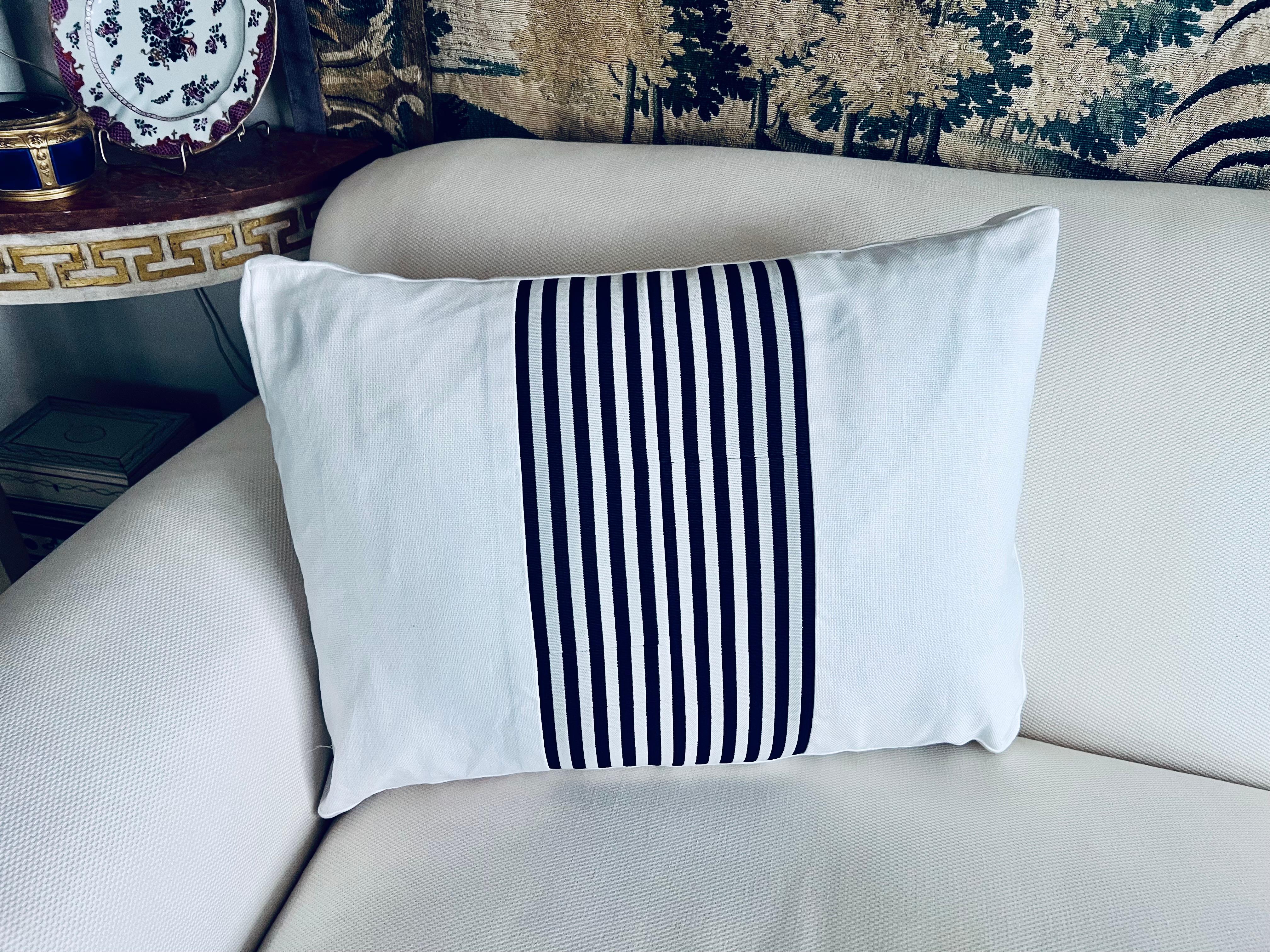 Coussin réversible en tissu rayé bleu marine découpé et assemblé à la main dans le tissu blanc.  Une fermeture à glissière aveugle se trouve à la base. 
Le tissu blanc a une armure de lin en coton.
L'insert est en plumes et en duvet.
L-22”
H-16
