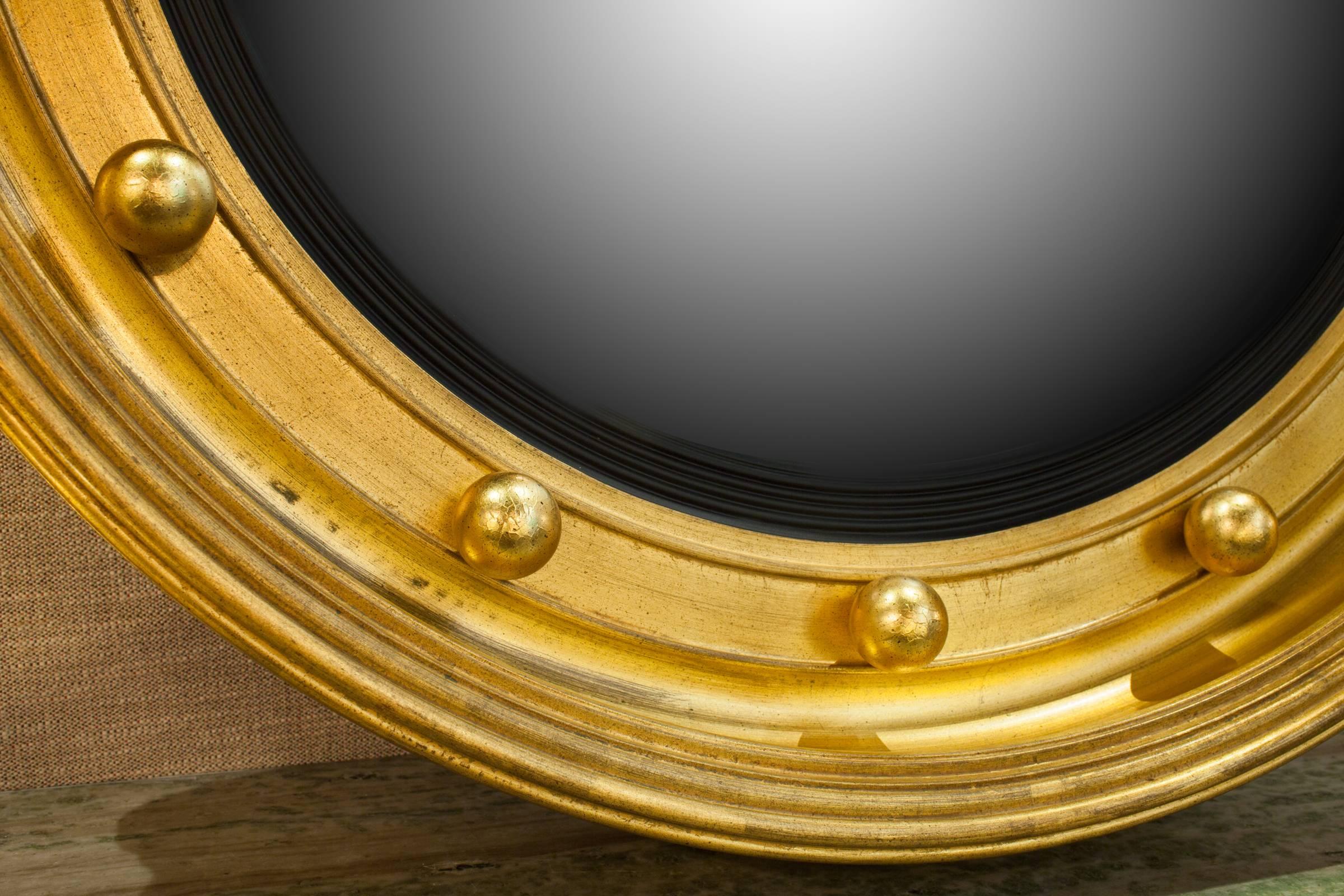 A very beefy vintage Federal style gold leafed bullseye mirror with convex glass set into a molded slip. The 13 gilt balls represent the 13 original colonial states. Some distressing in the silvering. Hand made and hand gold leafed.  Signed on the