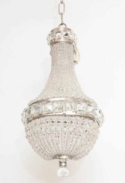 A small vintage chandelier with silver plate trim made up of small crystal beads, square faceted crystals and a beautiful finial. This charming and glamorous piece would be perfect for a small space or powder room. Newly rewired.