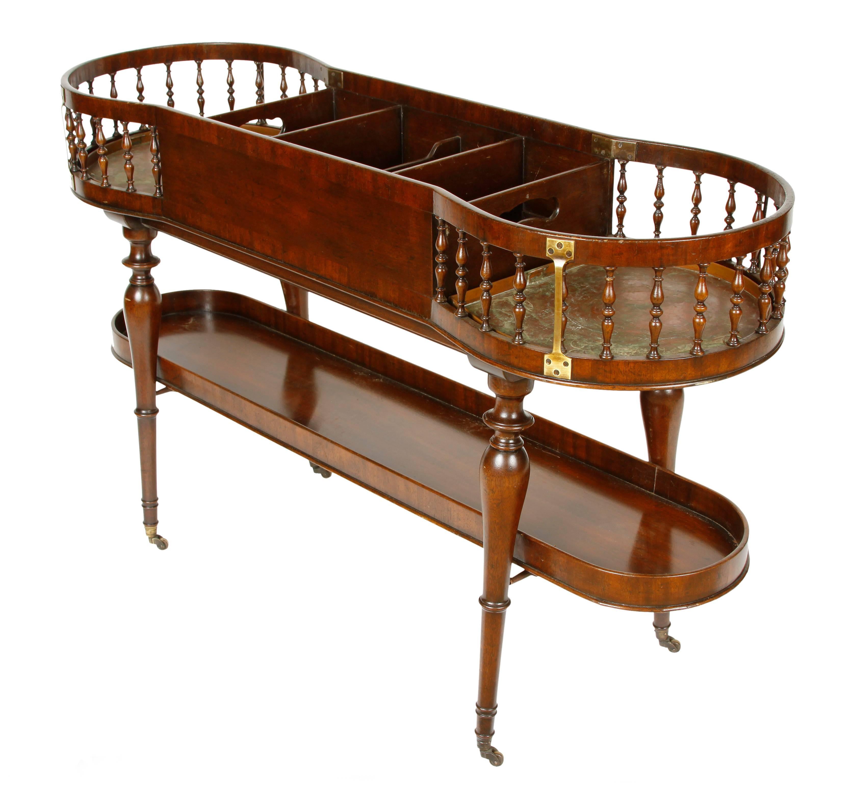 This unique English Regency bar has both form and function. Sitting atop turned legs on casters, the upper section consists of six divided spaces, all fitted with the original copper liners. The two rounded end compartments feature open sides with