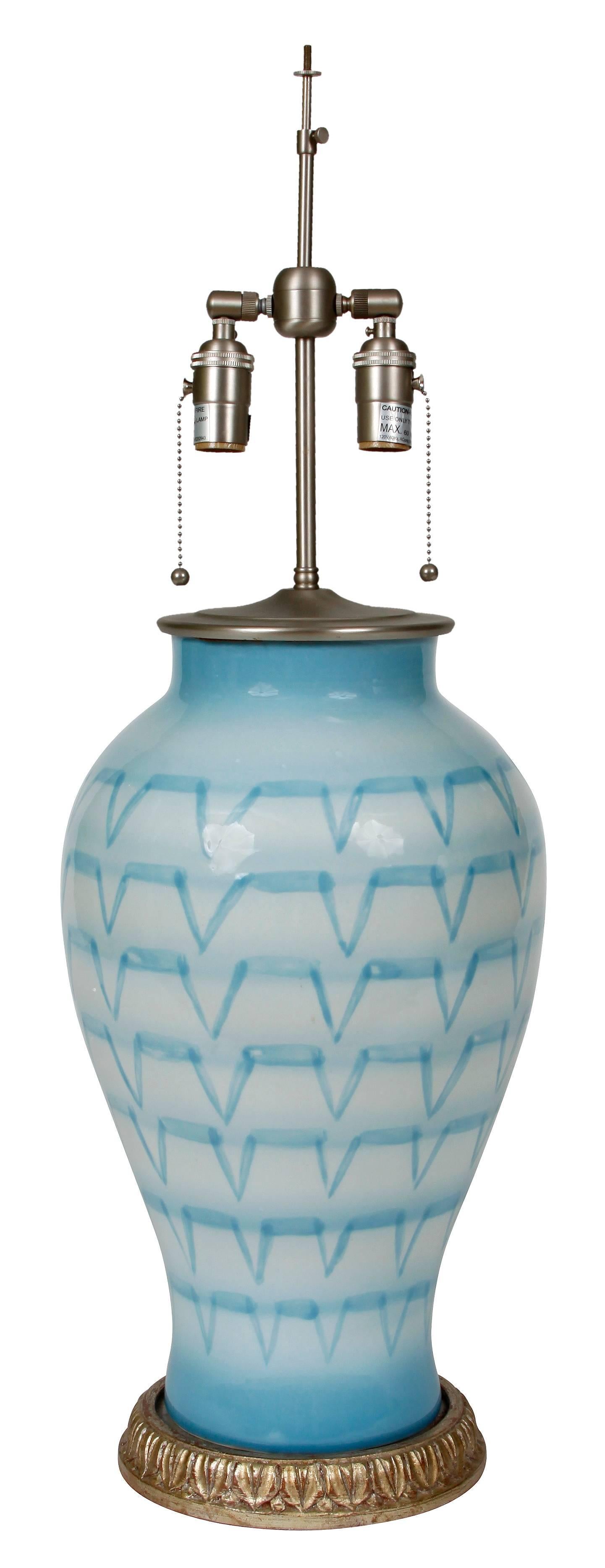 A beautiful pair of double socket ceramic lamps in a stunning blue glaze with a rose gold base. The lamps are from the Bunny Williams Bee Line collection.