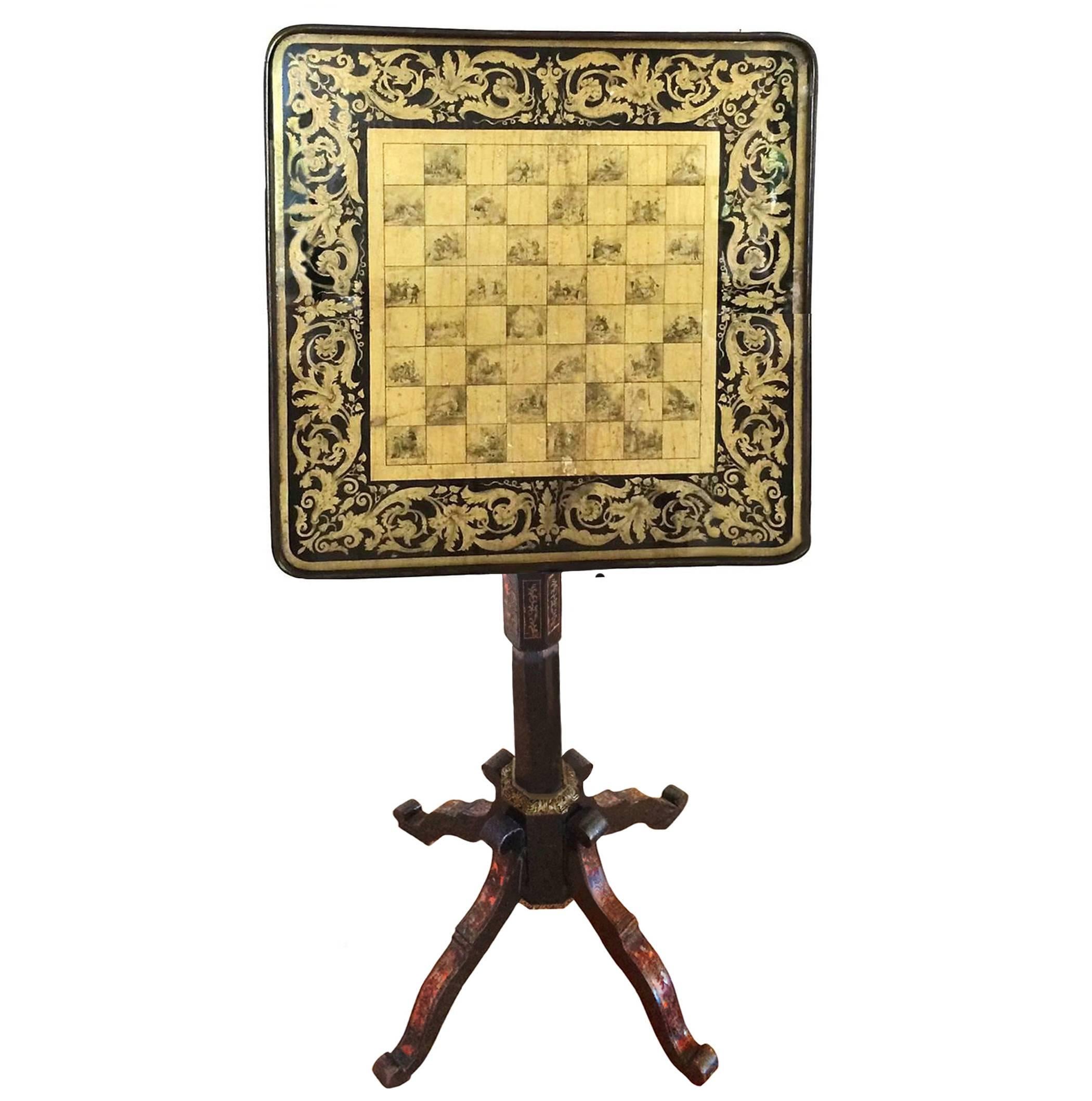 Italian ebonized tilt-top game table; painted top with intricately etched figures; tripartite base with boulle detailing; tortoiseshell and brass inset; 19th century.