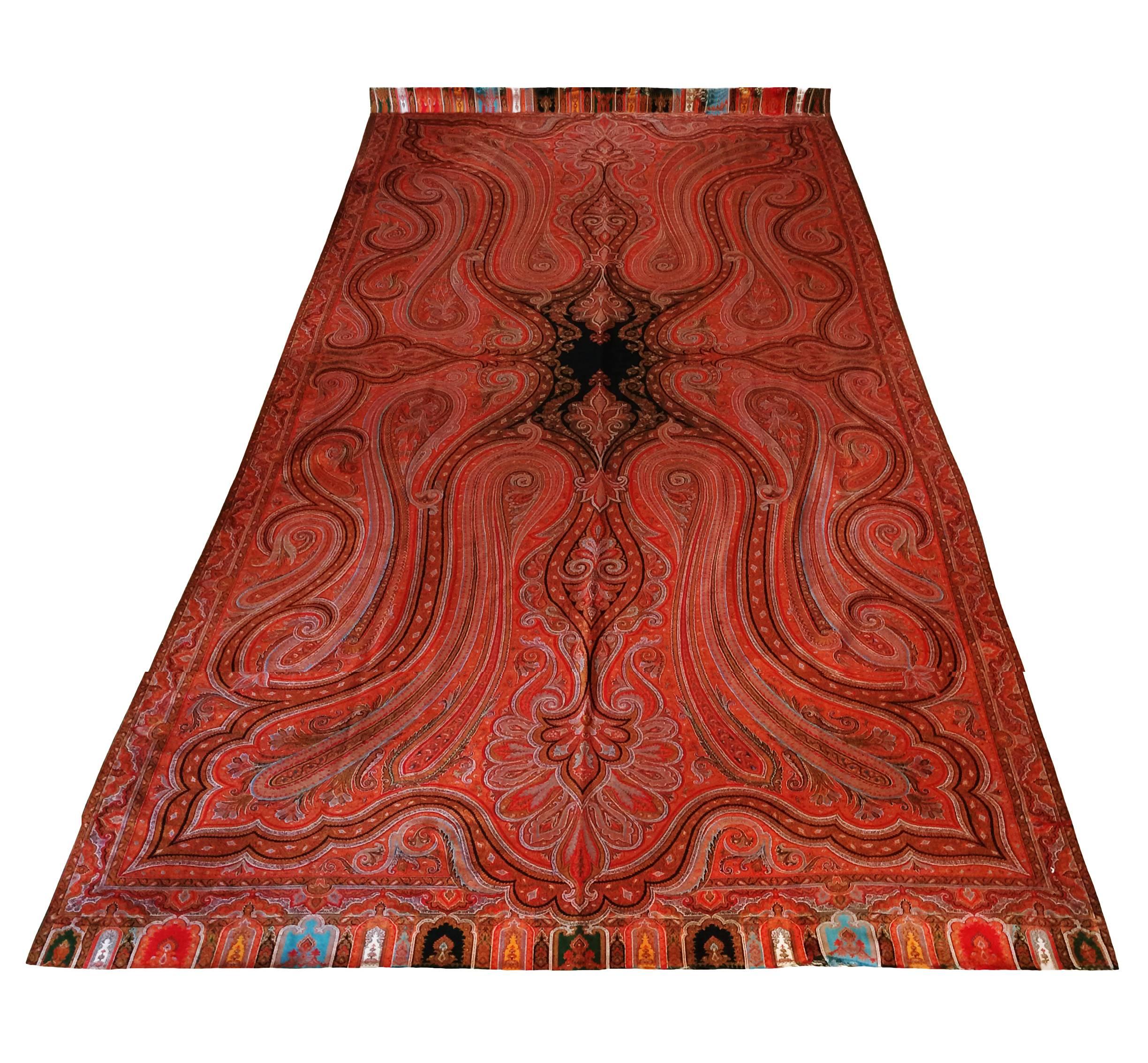 English Kashmir embroidered paisley textile; multicolored fringe. The hand needlework technique is known as "Rafugars". Separately woven and joined to the field, center medallion in dark cashmere. Predominately in red, green, blue and