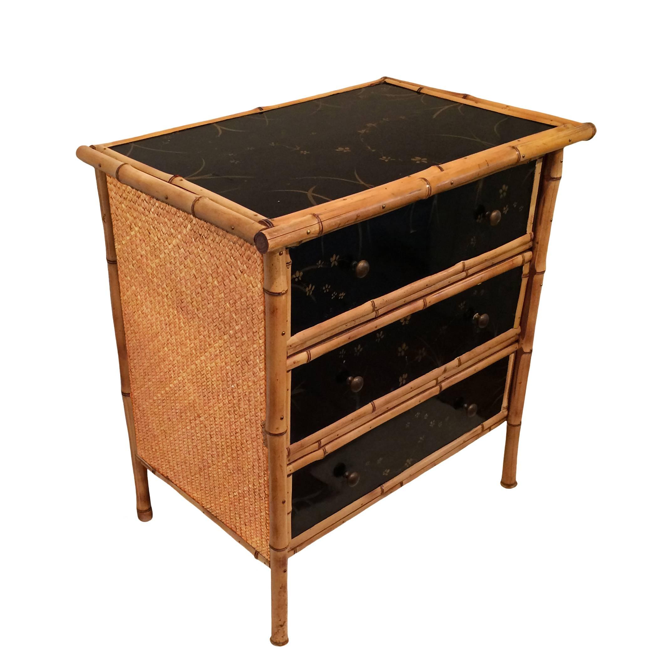 Charming French bamboo chinoiserie lacquer three-drawer chest with woven straw side panels; early 20th century. 
 

  