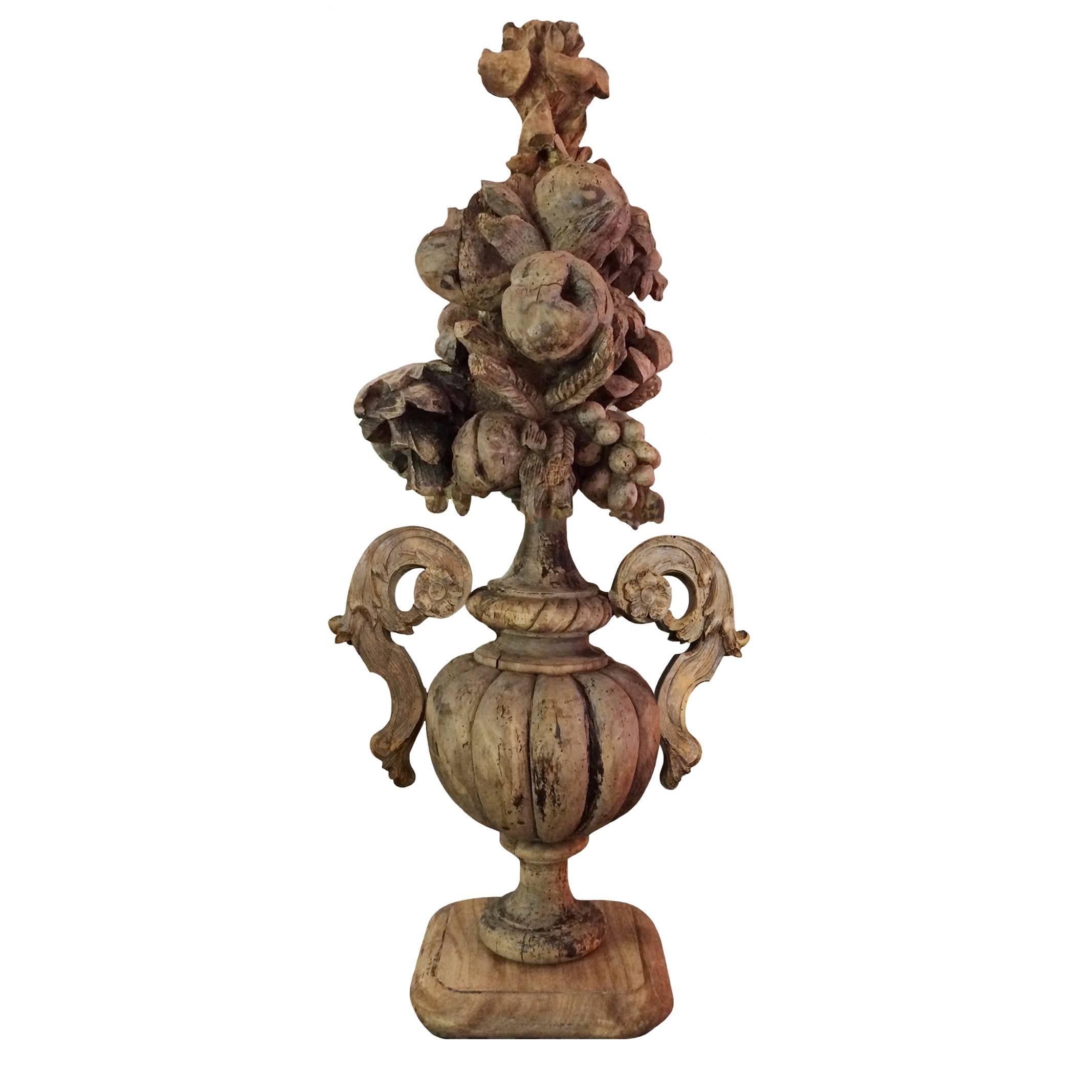 A pair of very tall, intricately carved French walnut urns; topped with a cornucopia of fruits and flowers, 18th century. Spectacular carving all of the way around. Natural aged patina.
