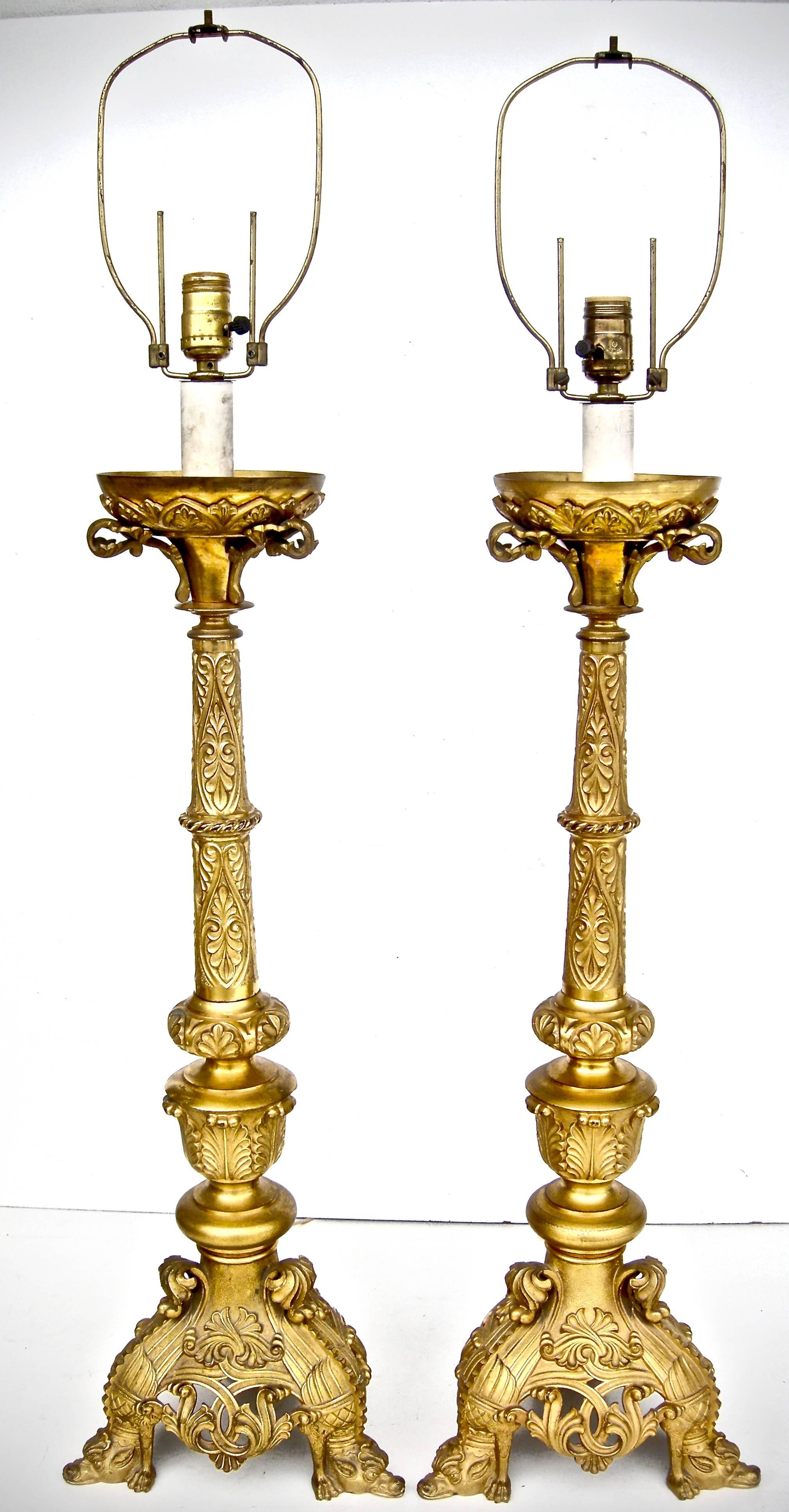 Elegant pair of, early French, over-scale, gilt bronze pillar lights. Rococo-style, having top bowl bobeches supported by highly detailed and ornately embossed, foliate-style, scrolled columns. Reticulated and flowing scrollwork bases accented with