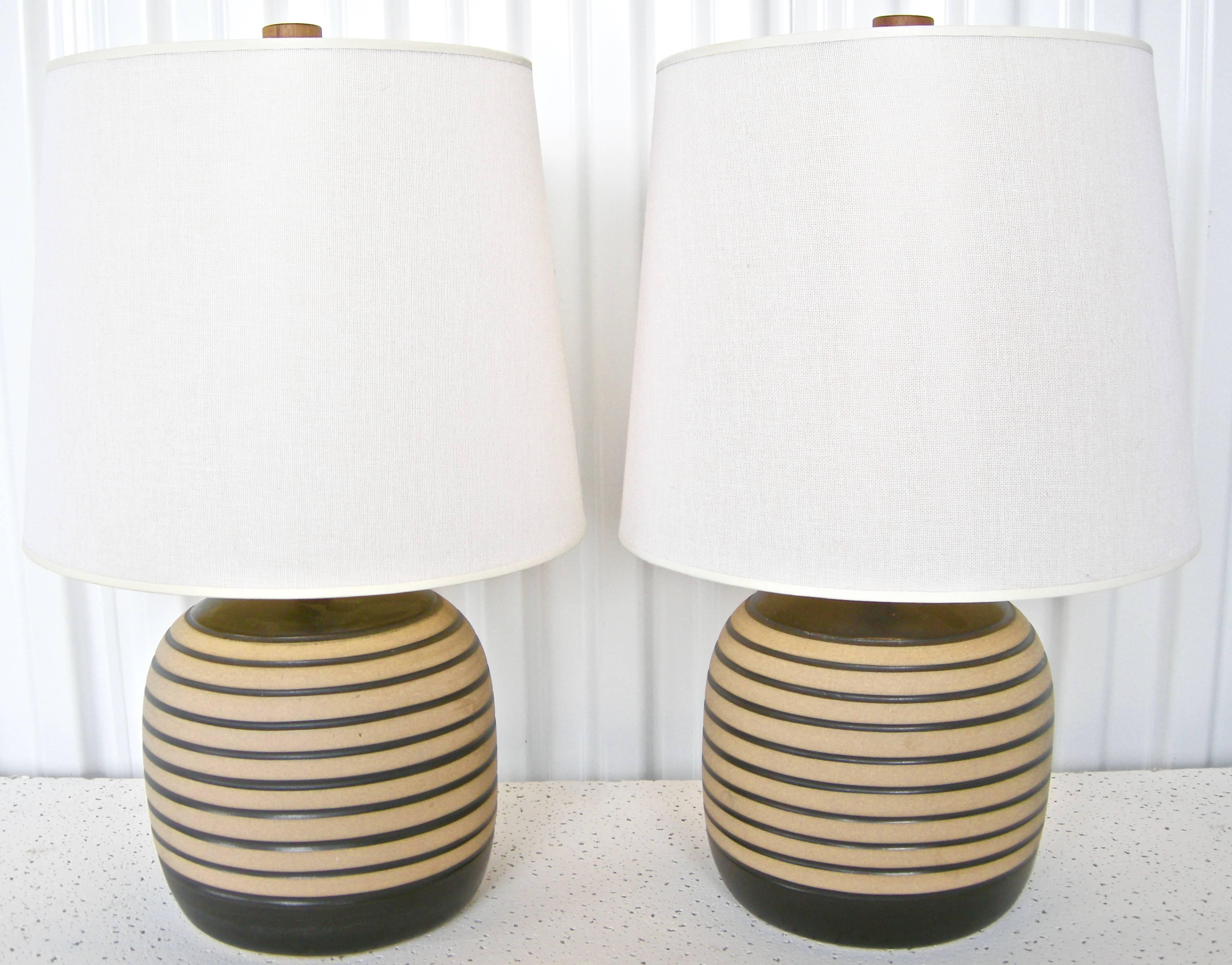 Terrific pair of vintage, Gordon Martz, table lights. Highly graphic and unique stacked ring design of bases in soft tan and brown palettes. Original shades and wooden finials. H below to finial top.Shade: 10