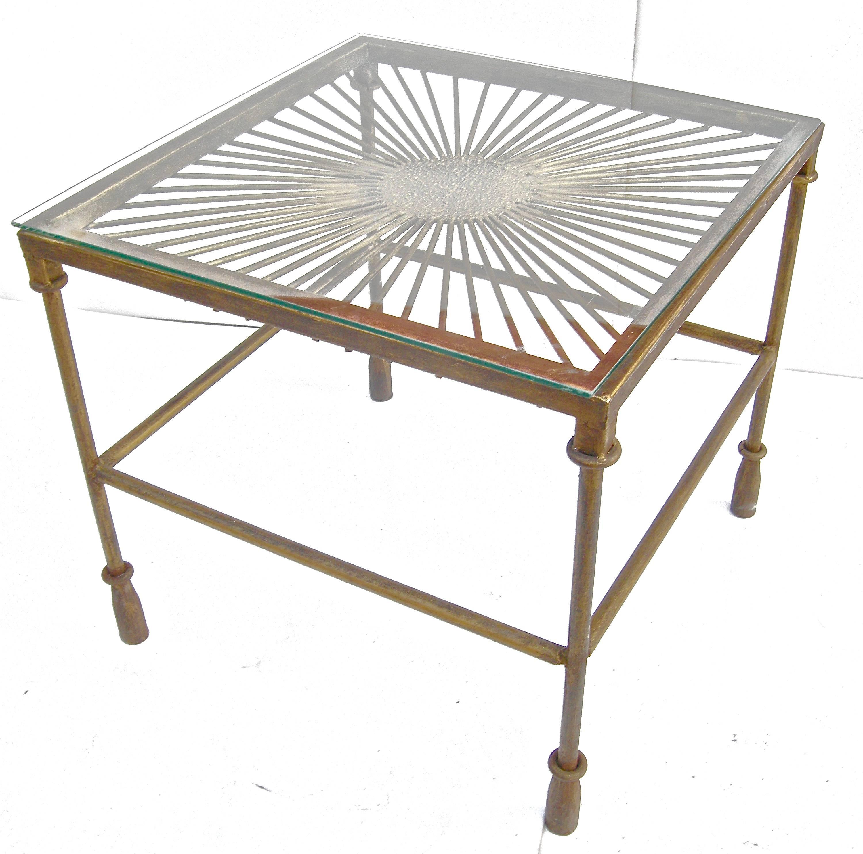 Striking, vintage French, side table in the Brutalist style. Heavy, bronze finished metal with glass top. Spattered centered medallion center top with radiating spoke surface. Square frame resting on moderne French tassle-style feet. Graphic and