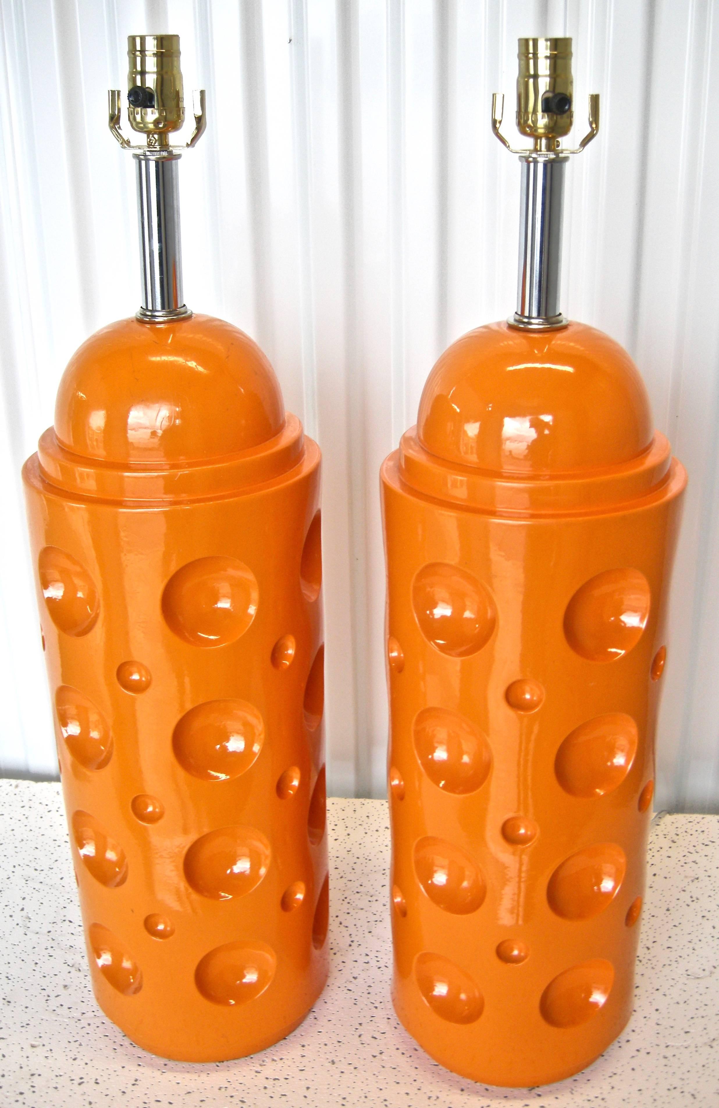 Terrific pair of striking, vivid, vintage tangerine table lights. Having faux moon-crater motifs with rounded stepped tops. Stylish chrome necks complement the overall graphic appeal. Newly wired and in working condition.