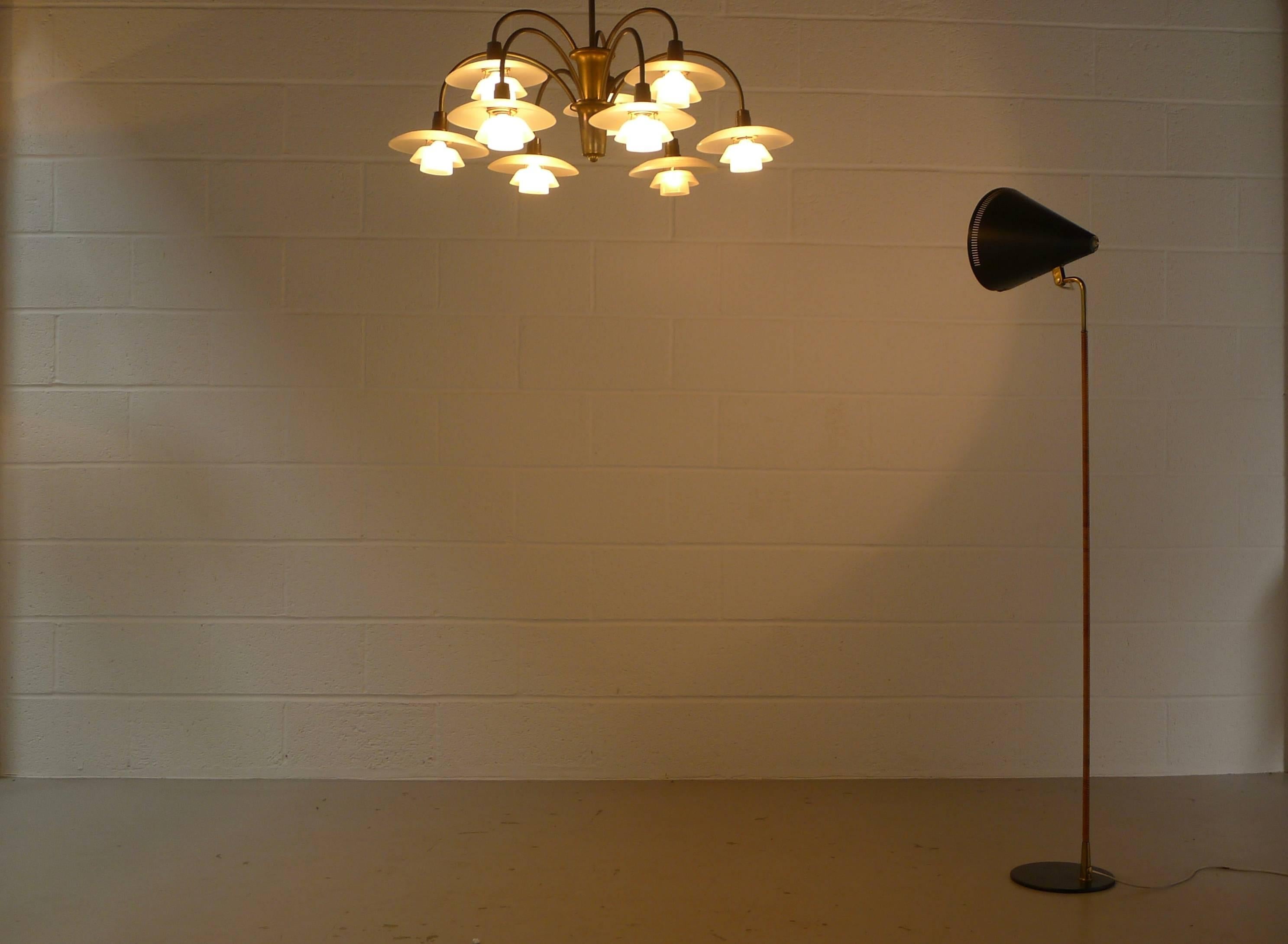 Paavo Tynell for Idman, Finland, model K10-10 rare floor lamp, enameled metal base, brass stem with original cane wrapping , and black enameled spun aluminium perforated adjustable shade. The lever mechanism stamped by maker "Idman" .
All