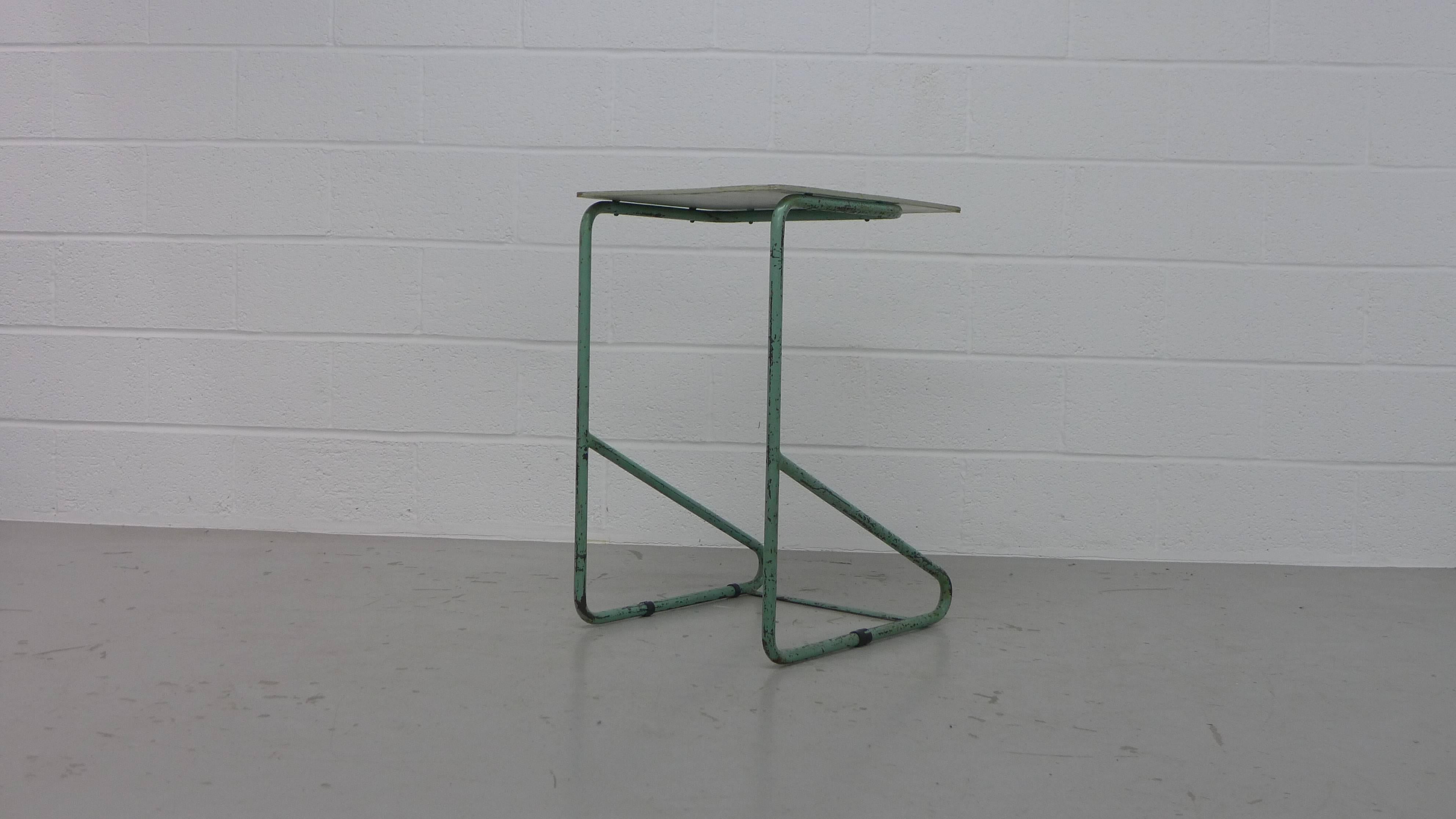 Alvar Aalto for the Paimio Sanitorium, Finland, 1932. A bedside table with it's original wood top and green metal frame, retains the small black sliders to the base section. The paintwork is original. Overall vintage condition with obvious signs of