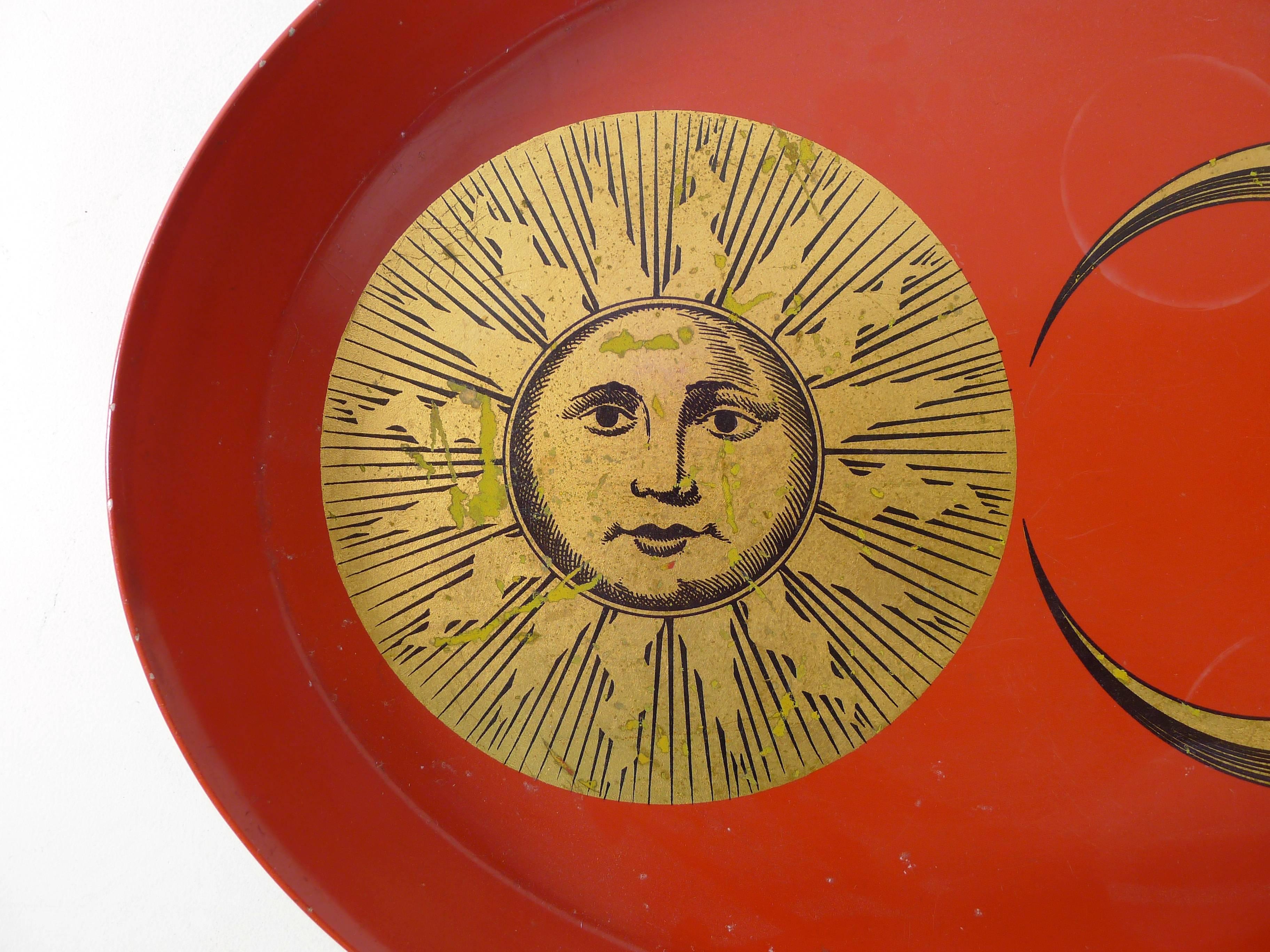 Piero Fornasetti serving tray, Italy, circa 1950s. Sun and moon motifs in gold on red background.
Images show age appropriate wear from use, label to the underside.