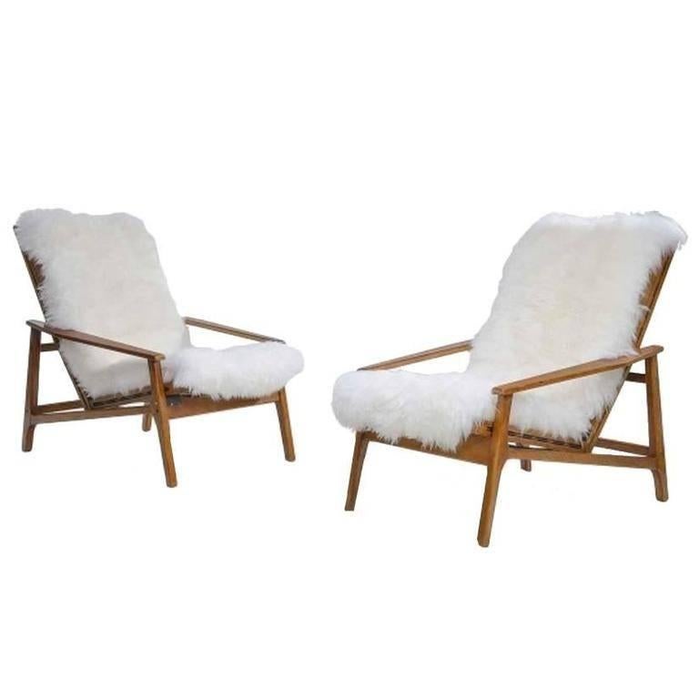 Pair of reclining Italian armchairs with wooden wing detail re upholstered in goatskin.