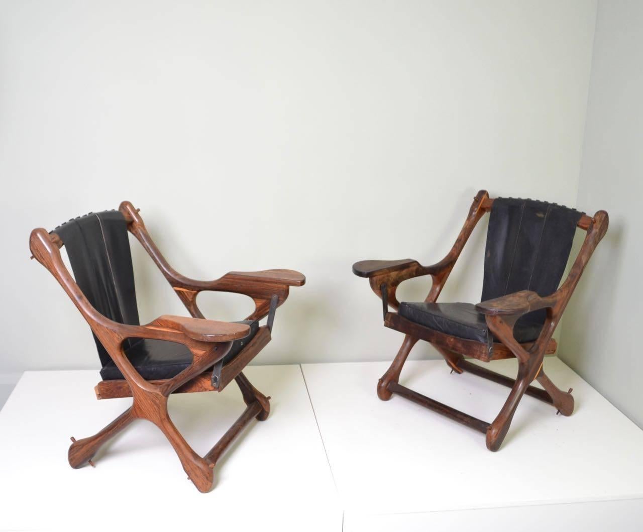 Pair of lounge chairs with rocking seats designed by Don Shoemaker
and retaining original 'Senal, Mexico' manufacturers label.
Cocobolo wood with black leather.
                