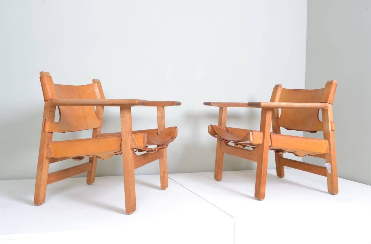 Pair of Spanish chairs with the twin oak back rail,
manufactured by Fredericia Furniture 
Original cognac leather sling seats and back.