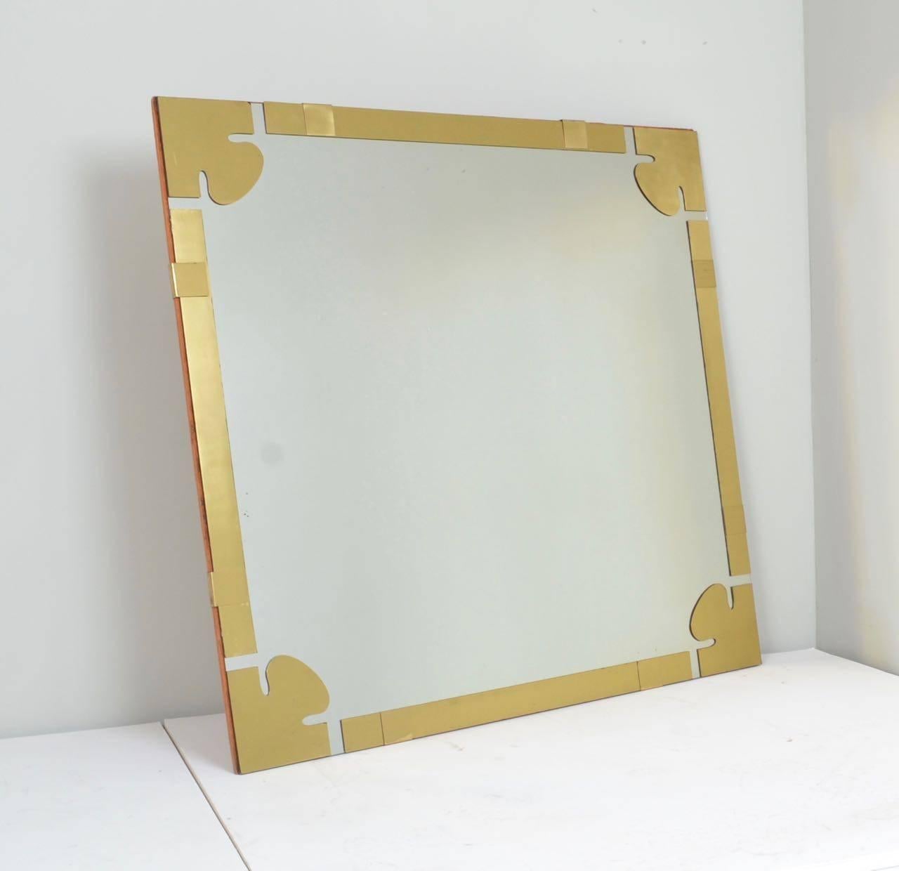 Sculptural lacquered brass pieces applied to the mirror with
an original felt covered backing.