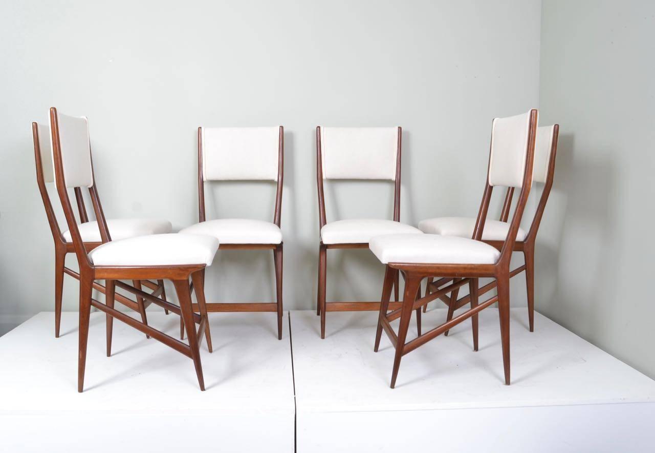 Set of six walnut and calico upholstered dining chairs designed
in the style of Carlo di Carli, Italy, circa 1950.
