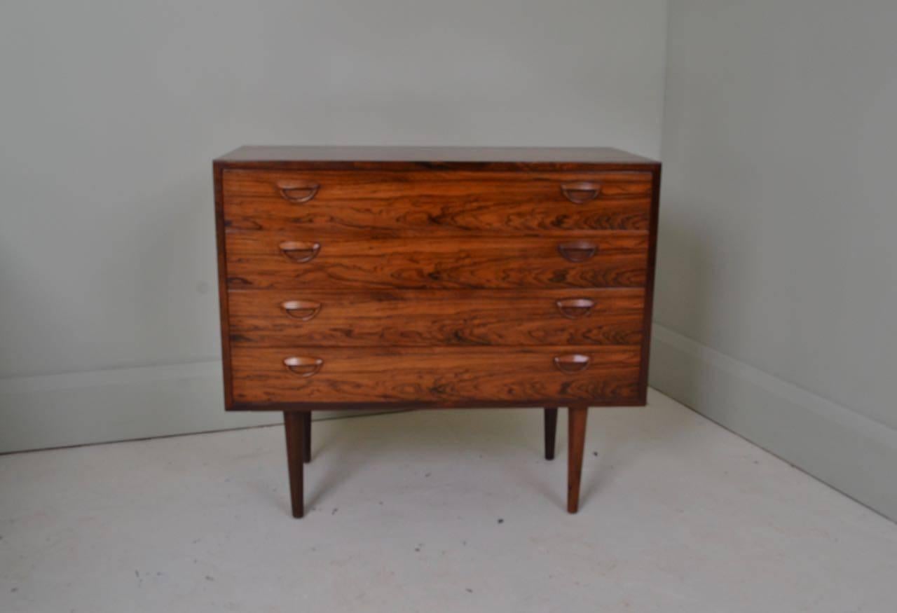 Four-drawer chest with beautifully figured wooden grain detail.
Designed by Kai Kristiansen and manufactured by Feldballes Møbelfabrik, Denmark, circa 1960.

The tapering wooden legs screw in so can be removed for transportation.