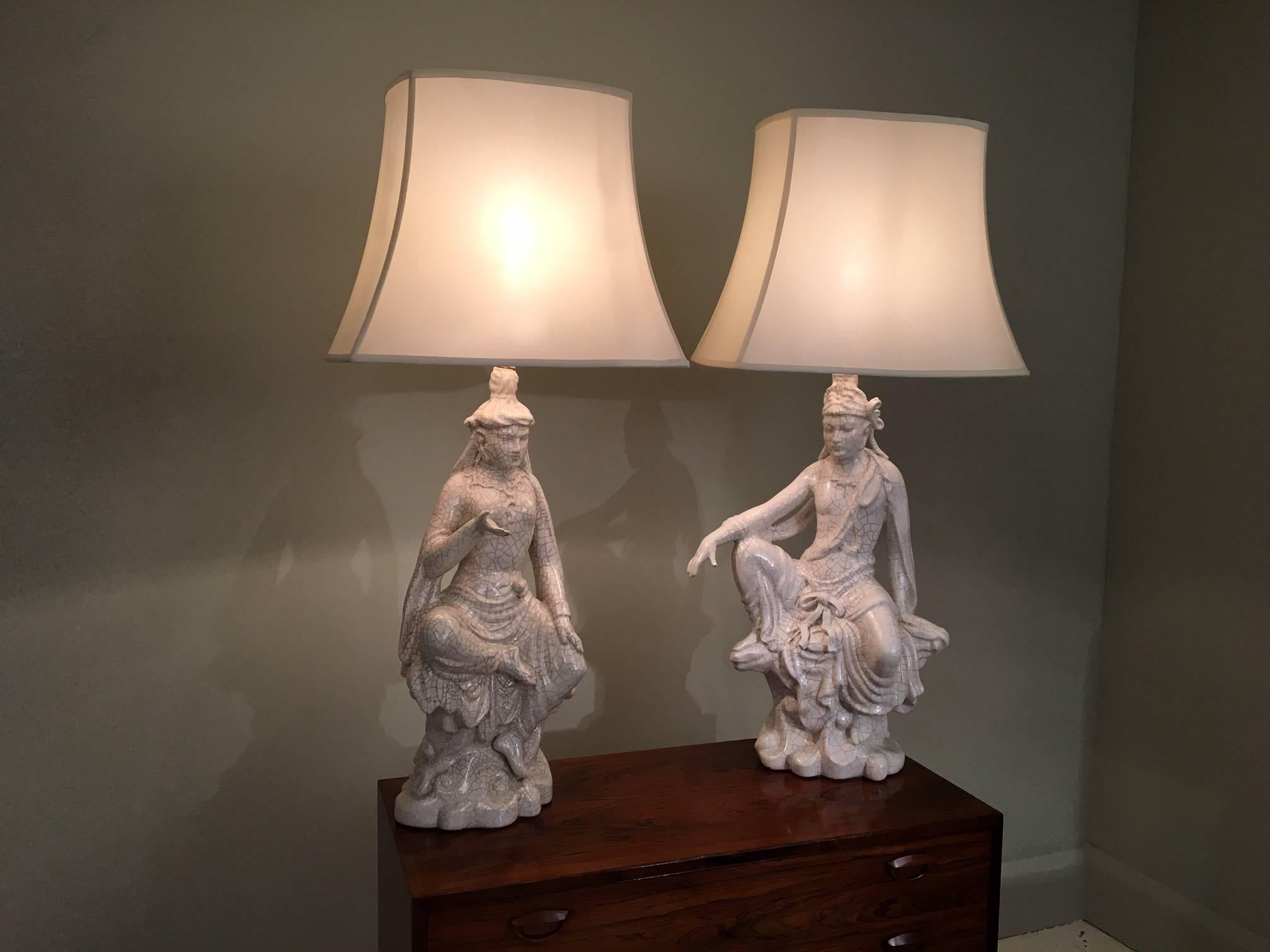 Pair of deity lamps finished in a crackle glaze ceramic. France, circa 1960. Very atmospheric and decorative pair of lamps, new oyster silk Pagoda 
shades , re-wired for the UK.

The ceramic figures are 66cm high without the shades,
The shades