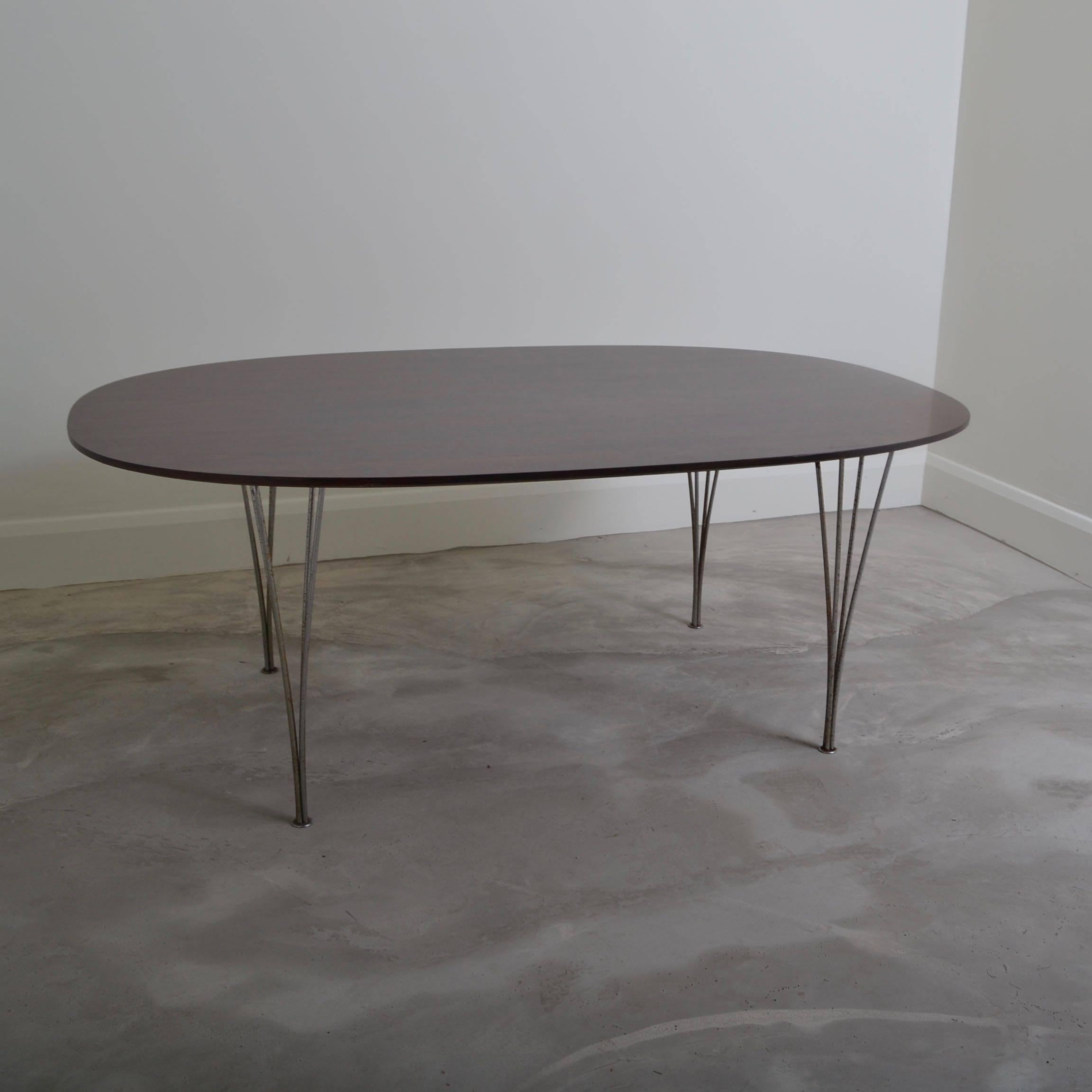 Super Ellipse dining table with chromed steel legs.
Designed by Piet Hein and Bruno Matthsson for Fritz Hansen ,
Denmark 1974 original label to underside.
The wood veneered top has been re-finished and the chromed steel legs are 
pitted with age
