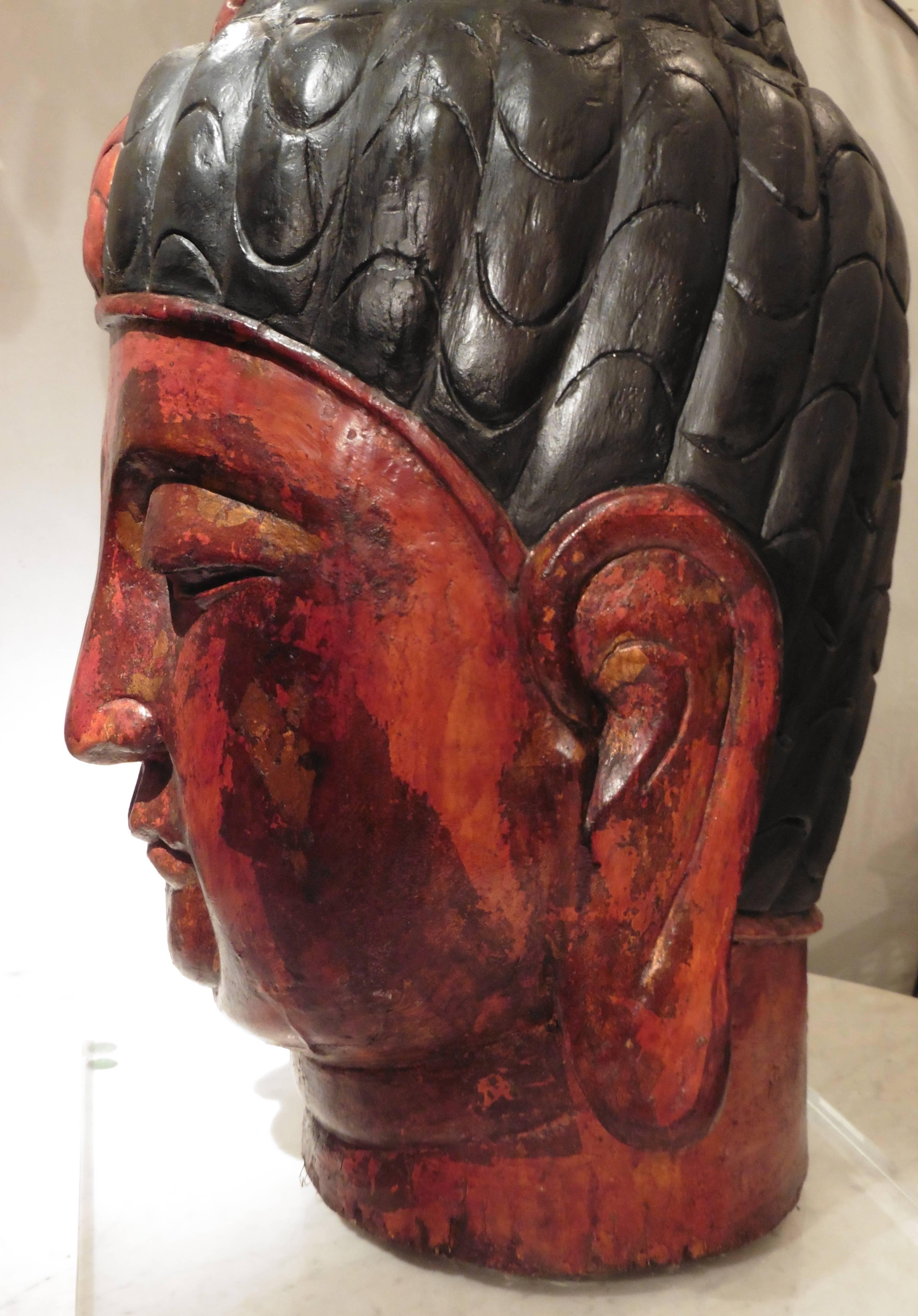 Monumental 19th century Indian painted carved wooden Buddha’s head with later Perspex Stand. The Buddha with a tranquil expression, and eyes half open. A gentle smile and the earlobes long and sweeping outwards, a spiral urna signifying the third