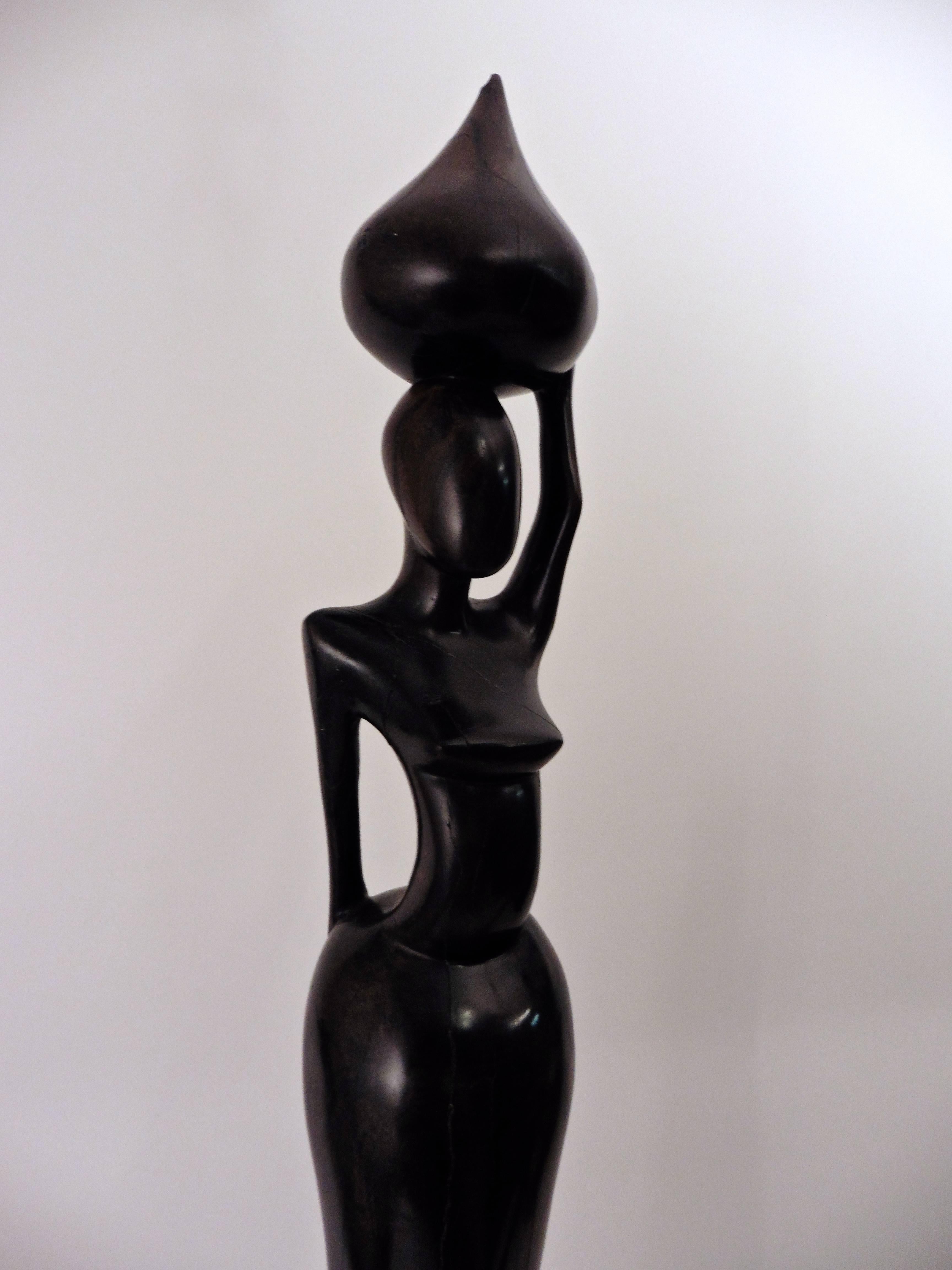 Pair of tribal male and female East African hardwood stylised sculptures in the spirit of Giacometti, circa 1960. The elongated figures elegantly sculpted from singe pieces of hardwood.

Size without stand: Small - 90cm high x 12cm diameter /big -