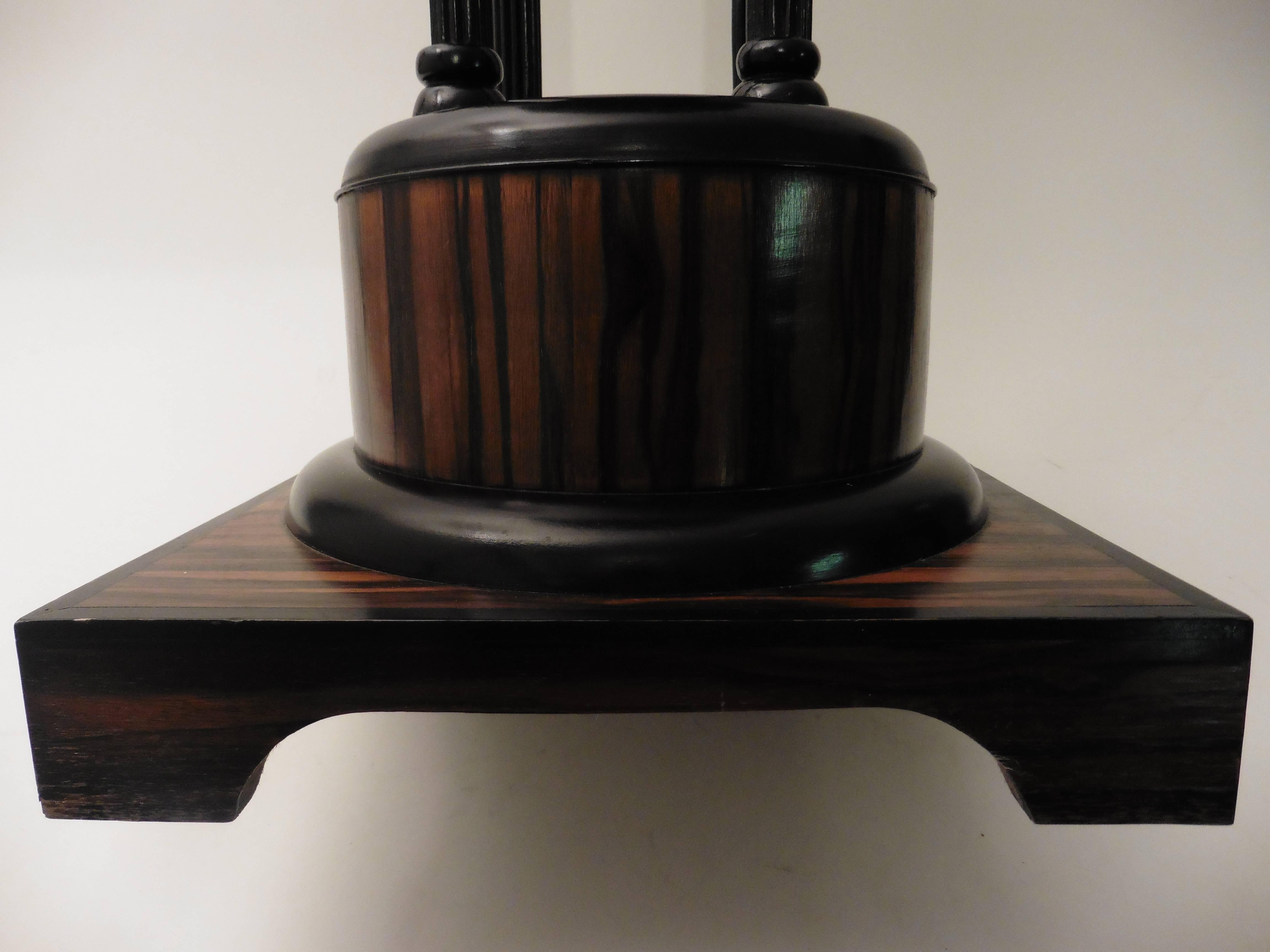 French Art Deco Macassar ebony wood table in the manner of Ruhlmann. The square base supports a round Macassar plinth, with an ebonized band. The main support is formed of four ebonized columns, finished with a simple octagonal table top, circa