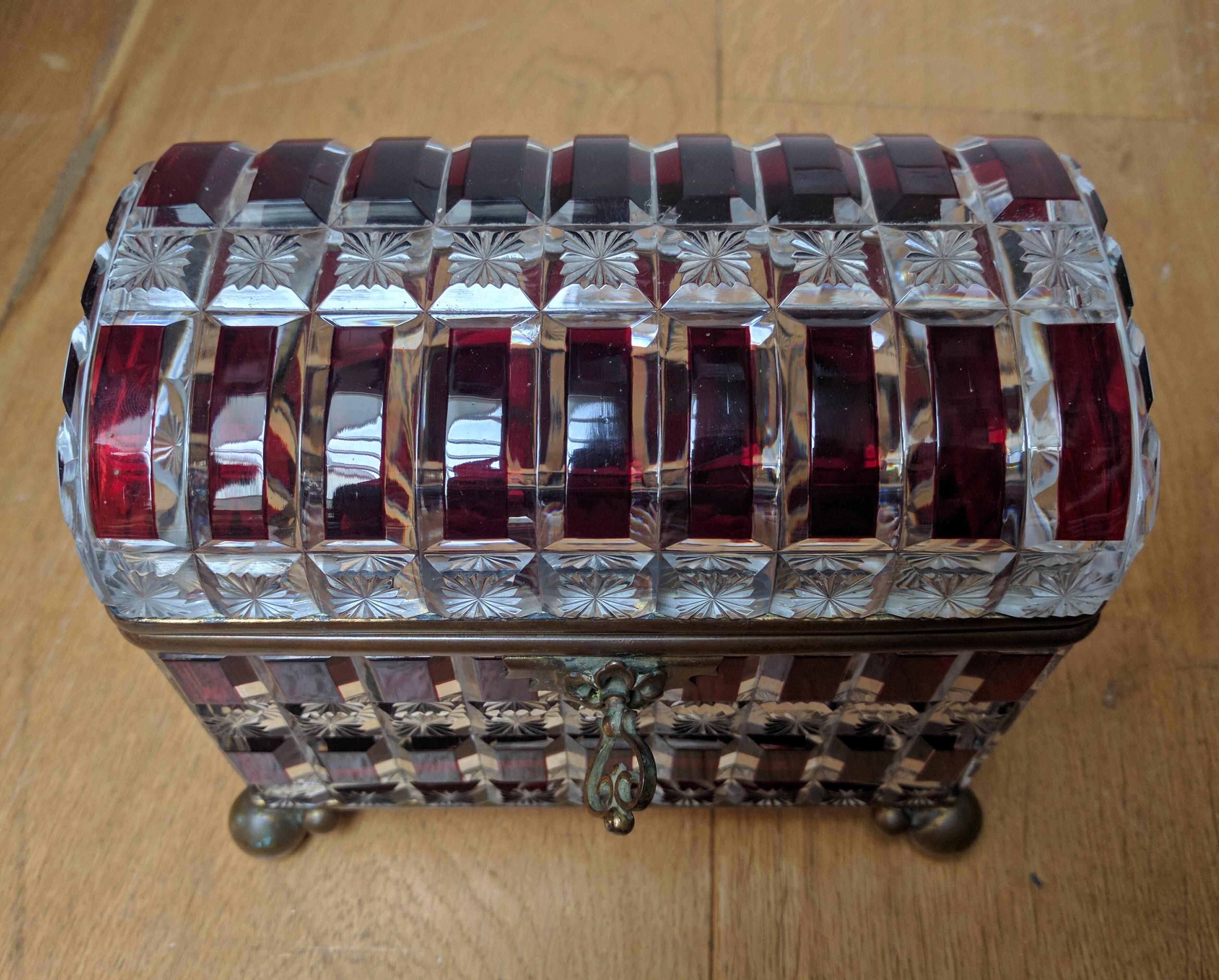 Large French domed top cut crystal and red overlay, and star cut rectangular casket with bronze bun feet and mounts and oversized ring handles on each size, original lock and key mechanism. Signed ‘Maison Siraudin, 17 Rue De La Paix,’ circa