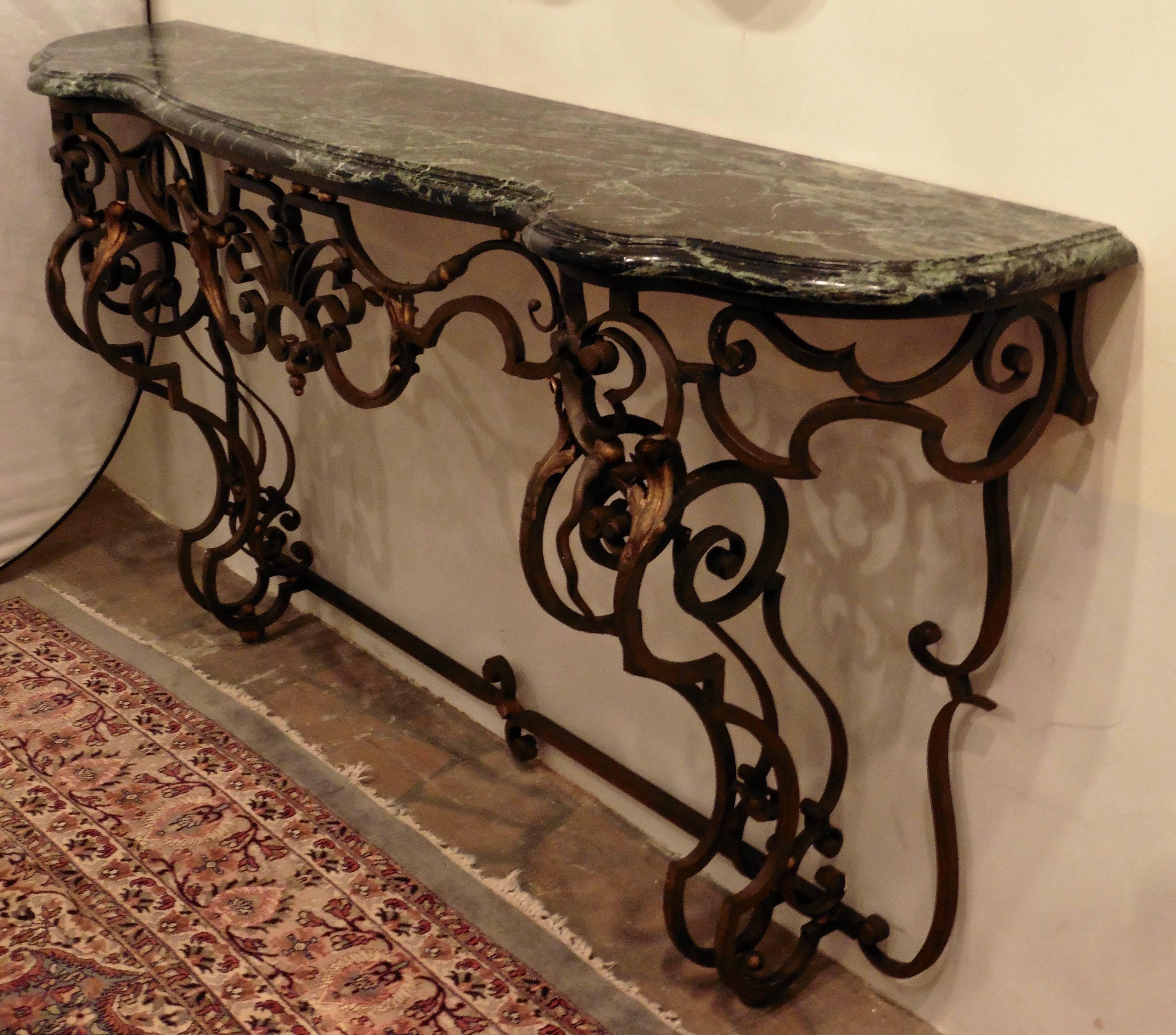 Large French console table with verd antique marble top, circa 1890. Wrought iron base with stylised acanthus centre decoration and two scrolling legs with gilded foliate details throughout. Decorative bracket for attachment to the wall.
    
    