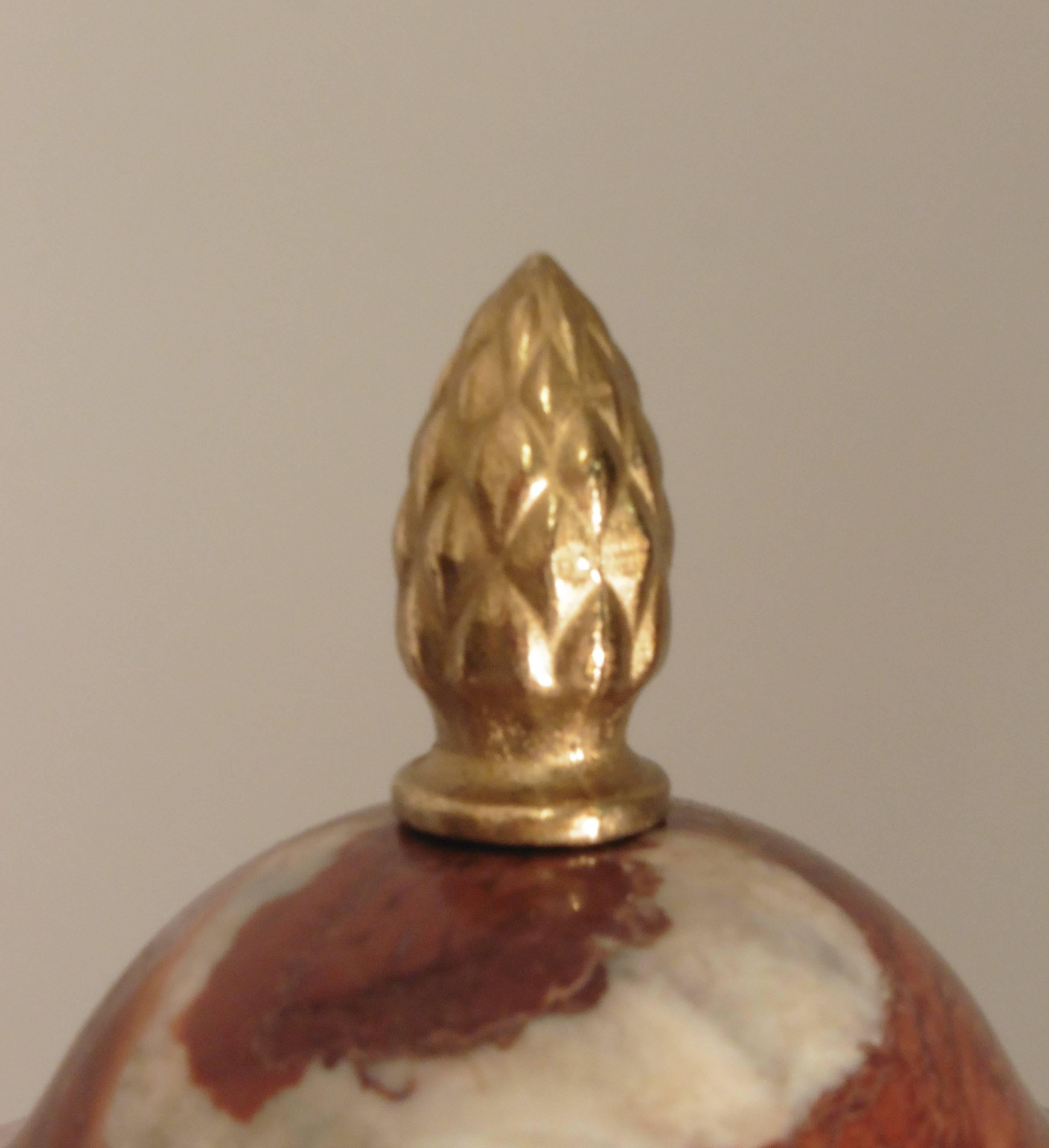 Pair of French Louis XV style Languedoc marble cassolettes with ormolu mounts, end of the 19th century. Pineapple finial over a twisting body with gilt floral ormolu decoration around the lid and handles, supported by three lion's paw feet on a