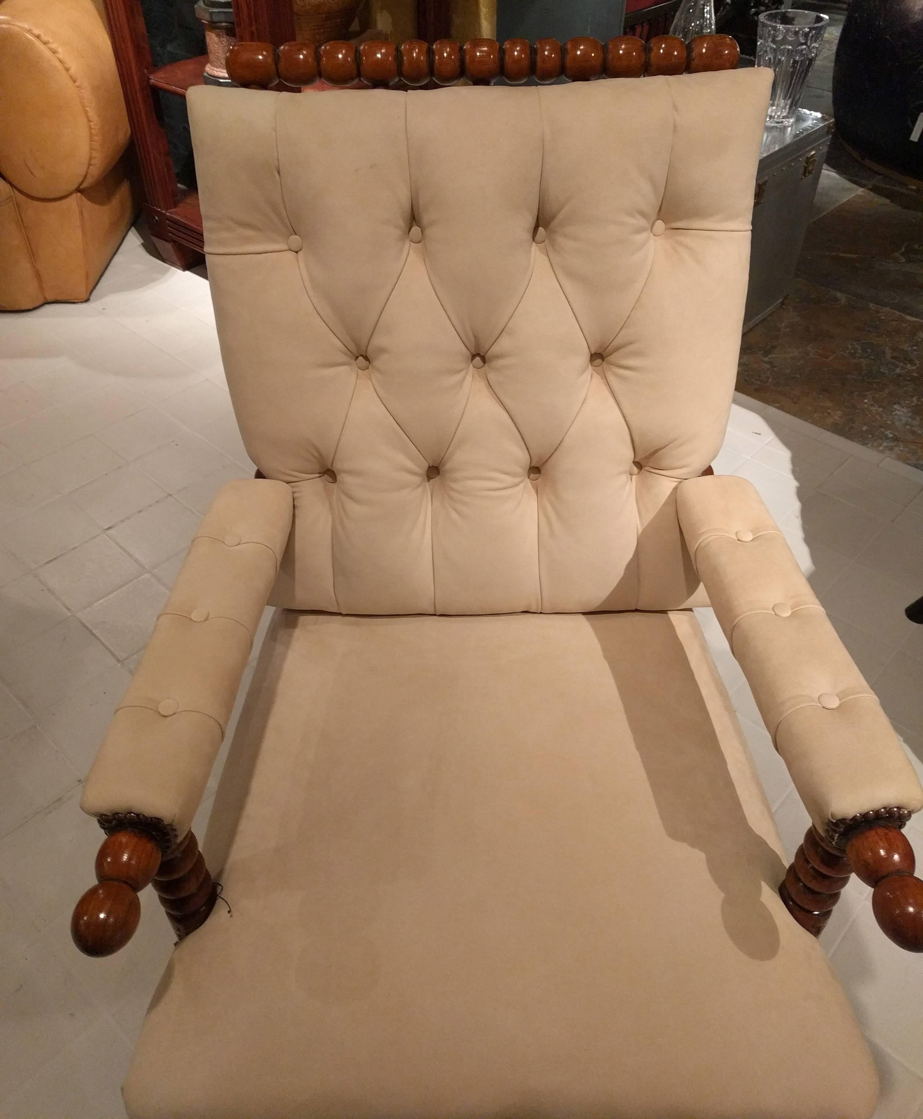 Matched pair of Danish bobbin turned spindle backed beech armchairs, circa1850. The chair's apron with a repetition of the bobbin carving featured throughout the legs and arms, upholstered in cream colored suede finished with antiqued brass