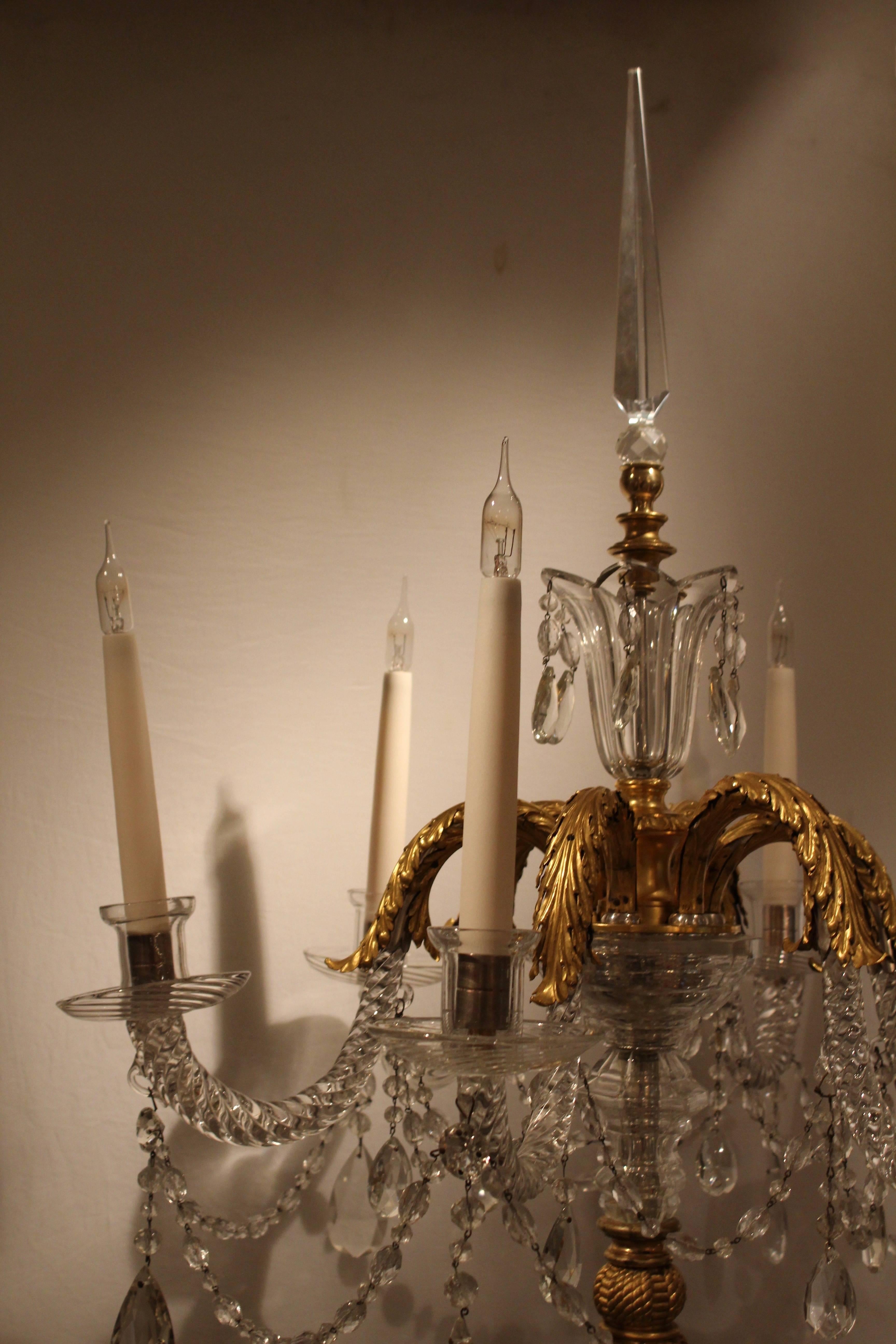 Pair of rare and unusual neoclassical floor standing candelabra, France, late 19th century. The carved marble base with acanthus leaf decoration is supported by four gilt bronze paw feet. The marble support leads to an ebonised wooden column