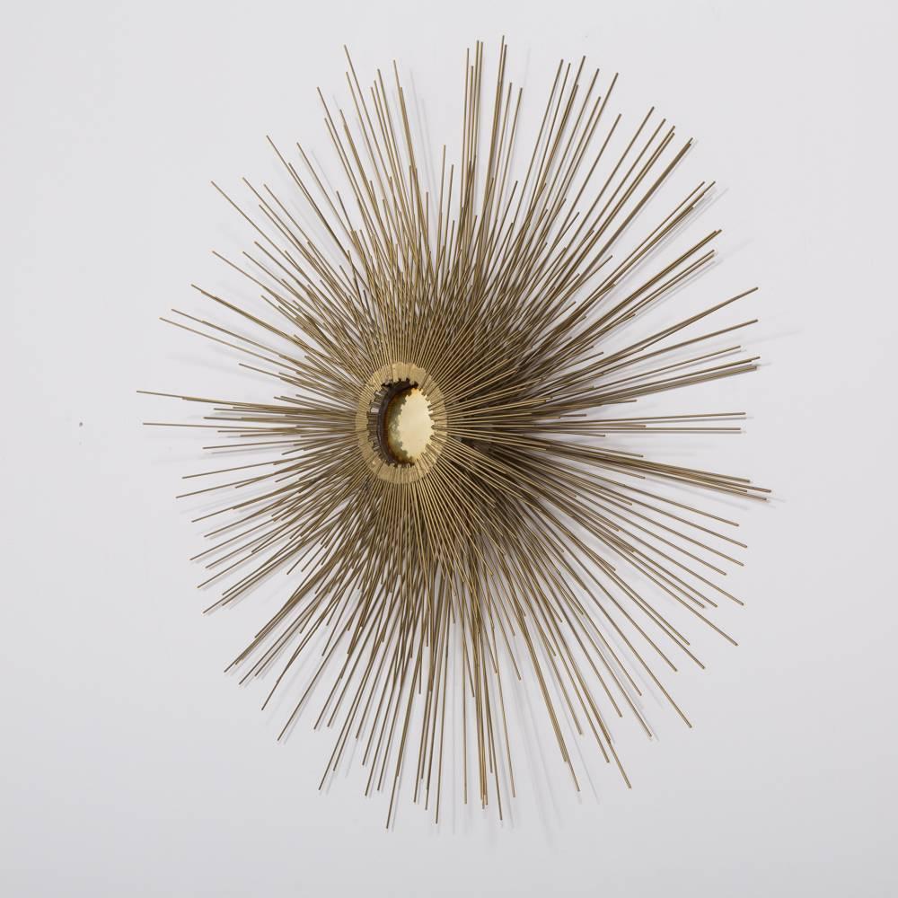 A three-tiered sunburst wall sculpture with polished brass center, 1970s.

Price includes 10% VAT which is removed for items shipped outside the EU.
