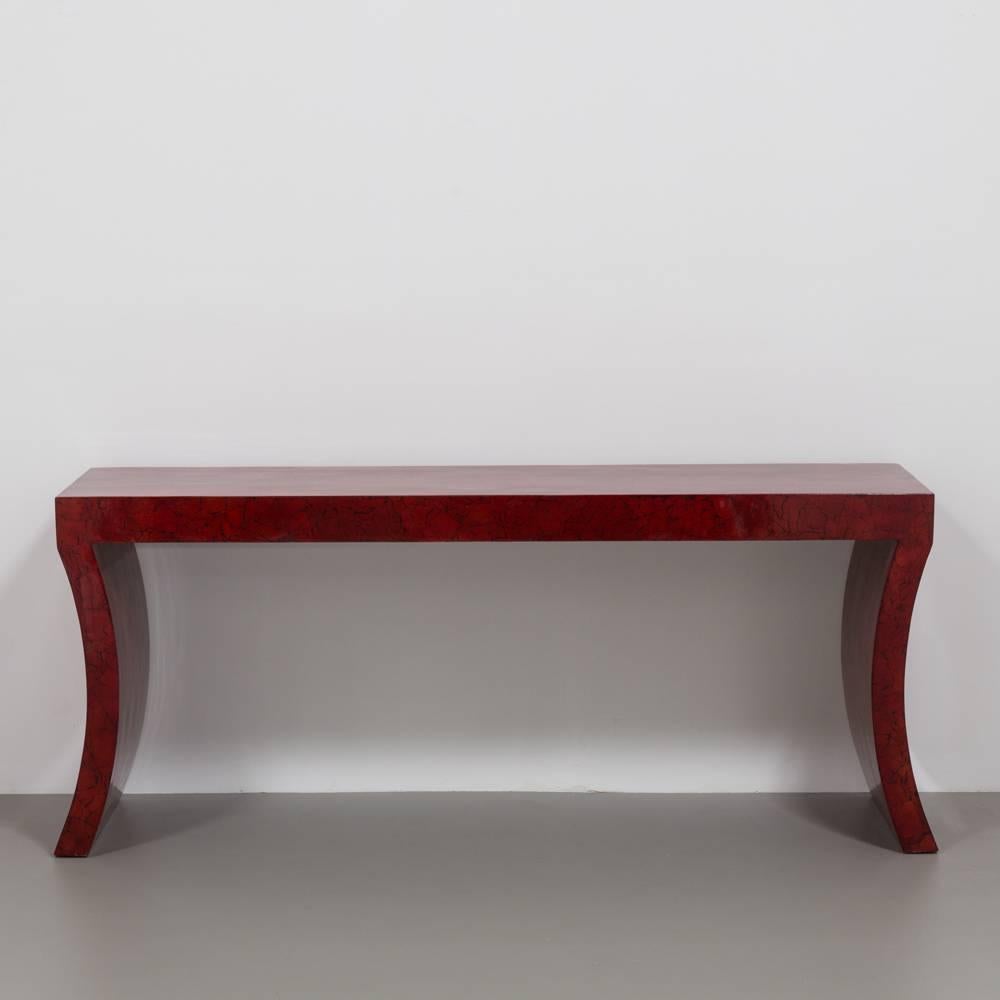 An Impressive Red Crackleware Finished console table with sabre shaped legs and a matching circular mirror with a black lacquer pediment 1980s The red is almost burgundy in appearance caused by the black crackle. The style of this console is very