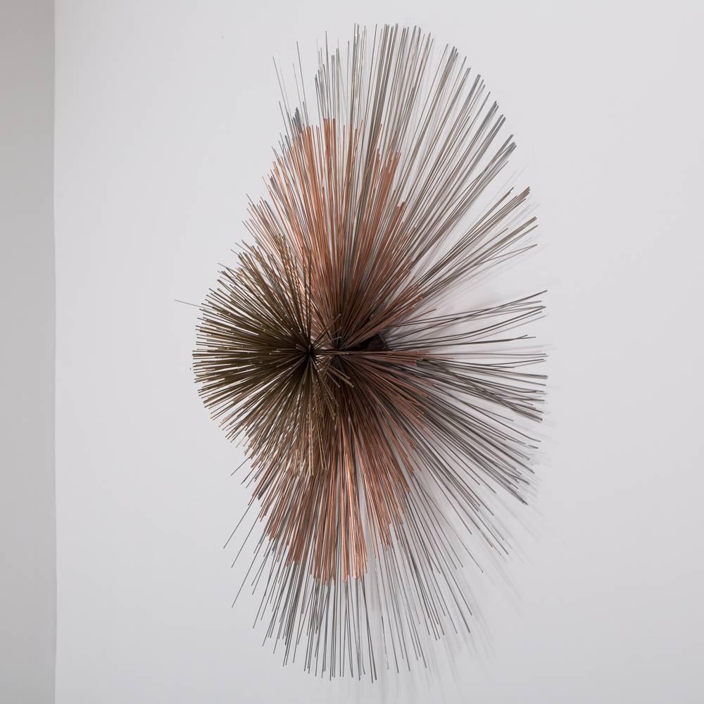 A large three toned starburst metal wall sculpture by Curtis Jere signed and dated 1984.