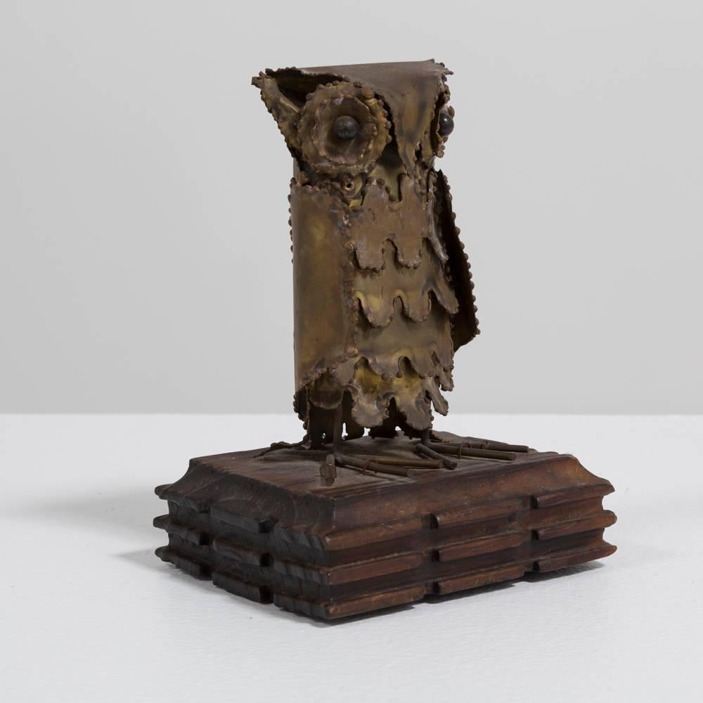 A small Brutalist metal owl on a wooden base, 1960s.
