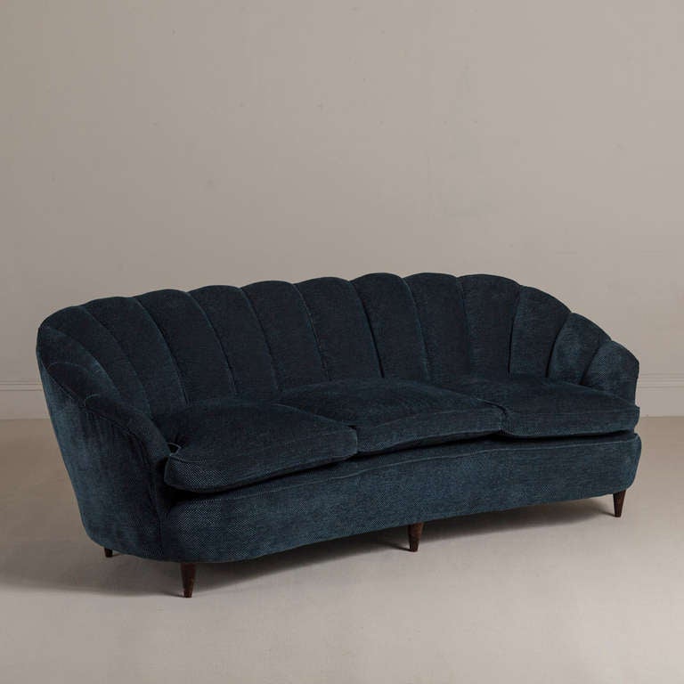 French shell shaped sprung back sofa on tapered ebonised legs in original navy blue upholstery 1930s.