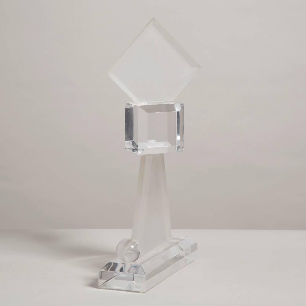 A 1970s clear and frosted lucite abstract table sculpture made up from geometric shapes on a twisted axis.
